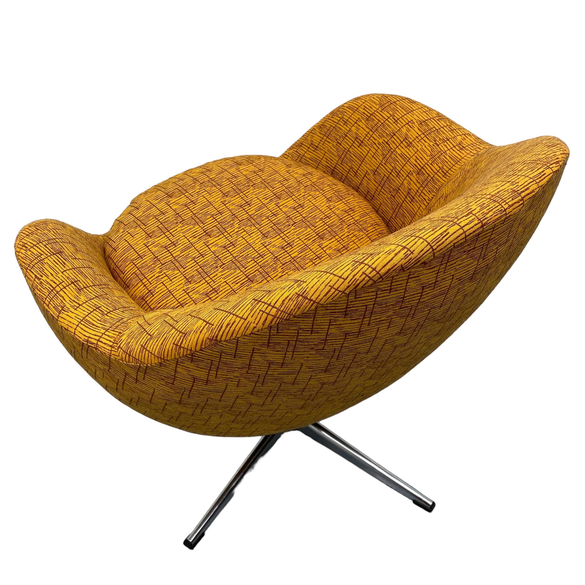 A fabulous midcentury lounge chair by Swedish manufacturers Overman. This Swedish swivel egg chair has a steel base & an interesting curved shape. The chair has been recently professionally reupholstered in orange vintage style fabric. A beautiful