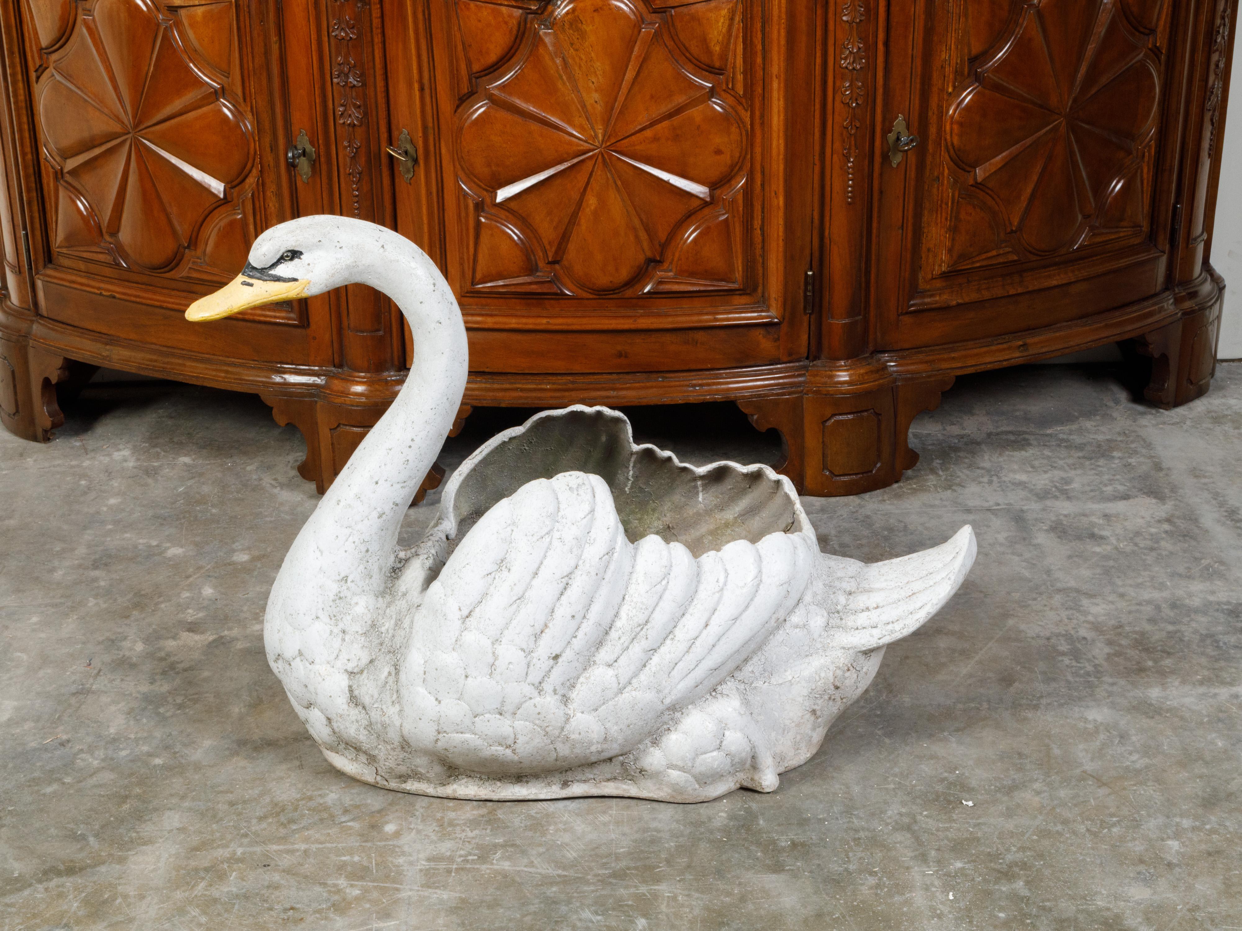 A vintage painted iron swan planter from the mid 20th century, with weathered patina. Created during the Midcentury period, this planter features a handsome swan painted in white, accented with black and yellow on the beak. Pierced in its center and