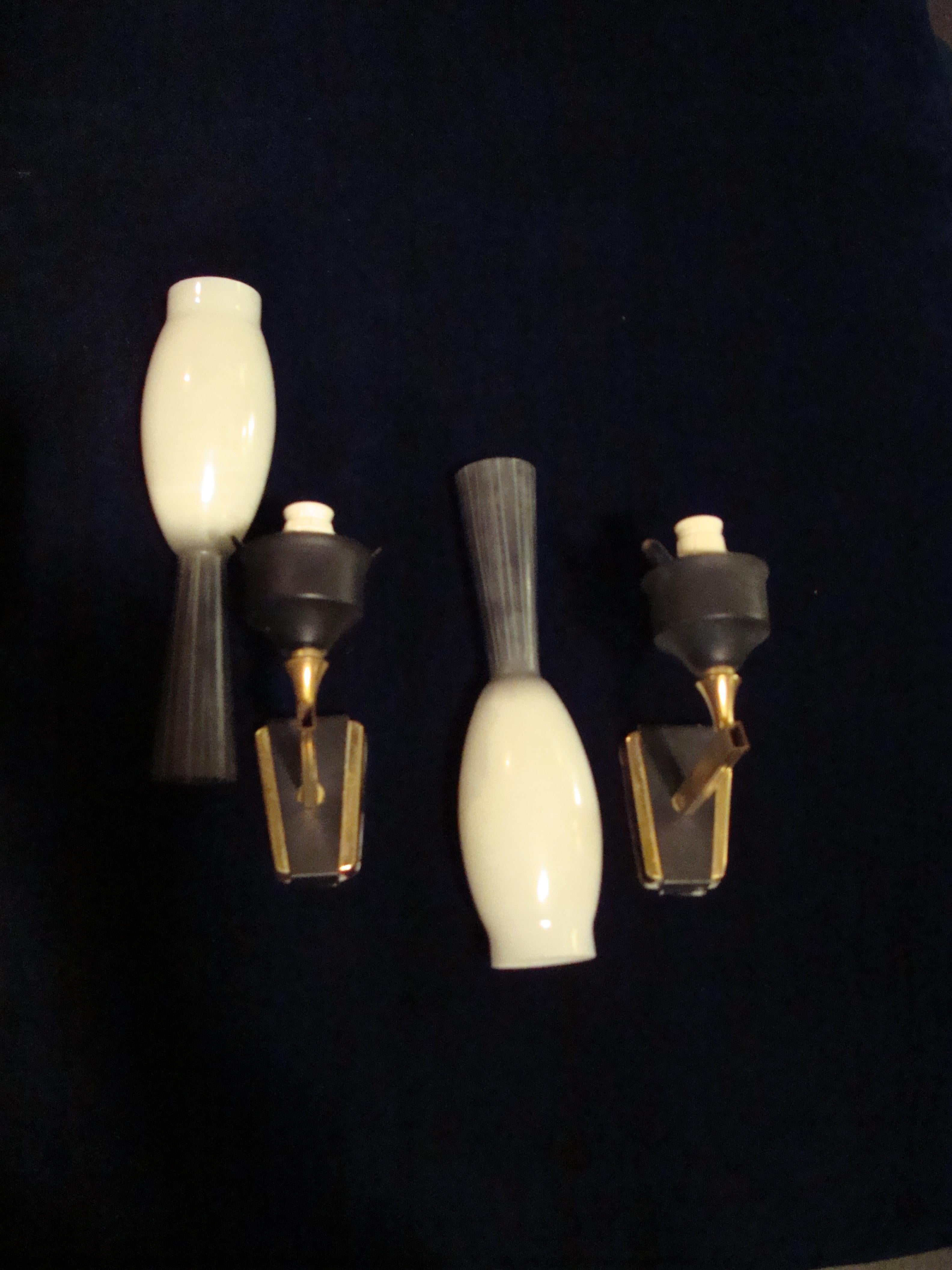 A pair of mid-20th century opal black and white glass wall sconces, the brass arm part black painted.
