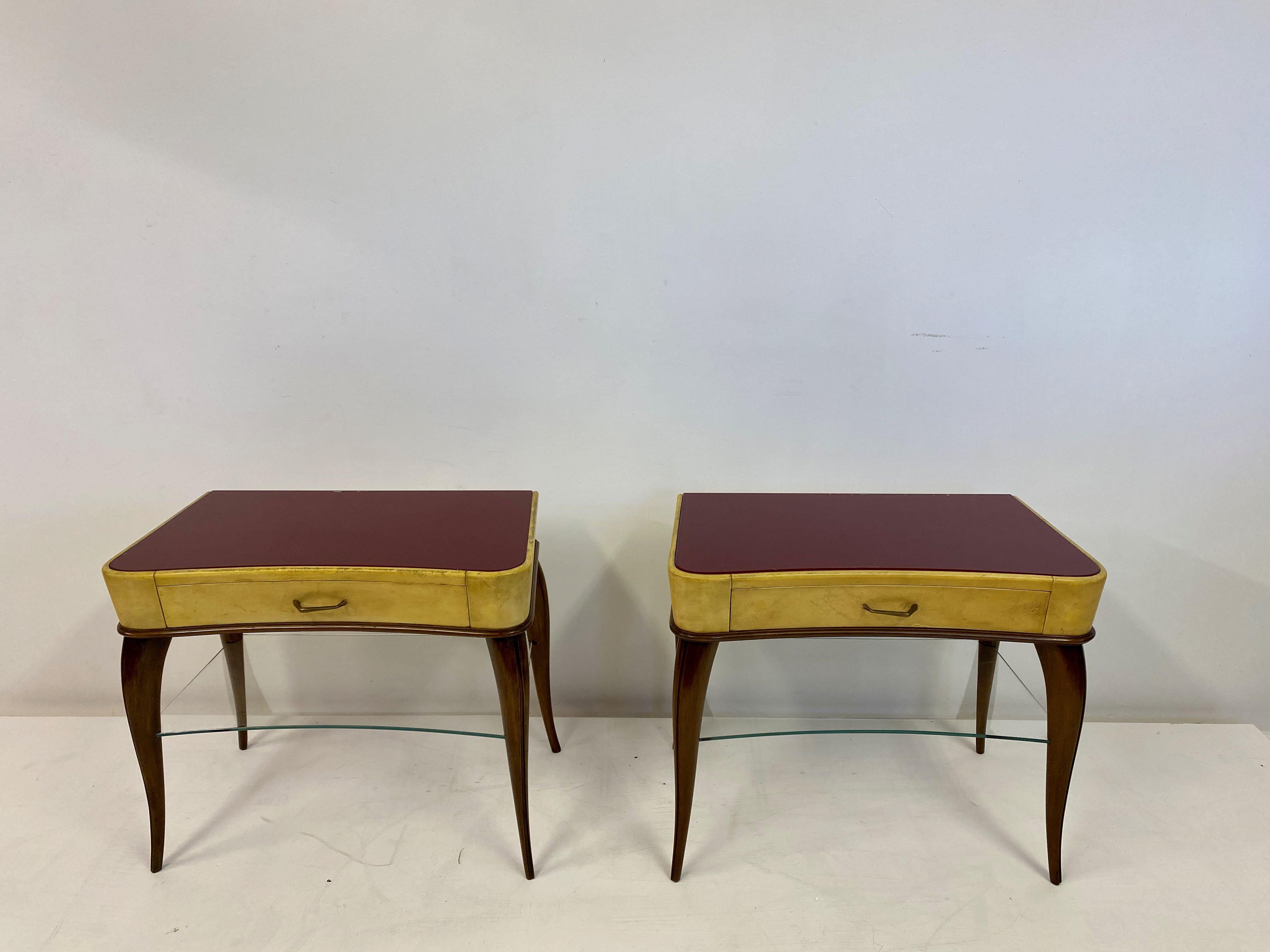 A pair of bedside tables

Red glass tops

Brass handles

Wood frame

Glass shelf

Parchment body

Italy, 1950s.
 