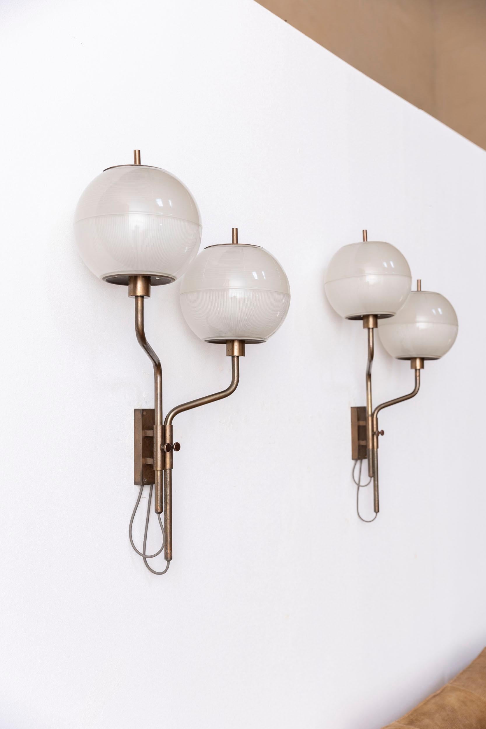 Ikonisches Paar Azucena Wandlampen, hergestellt in Italien in den 1950er Jahren. 
Die Messingstruktur in herrlicher Patina  enthält ein Paar originale Glasschirme.
Perfekter Vintage-Zustand.
 
