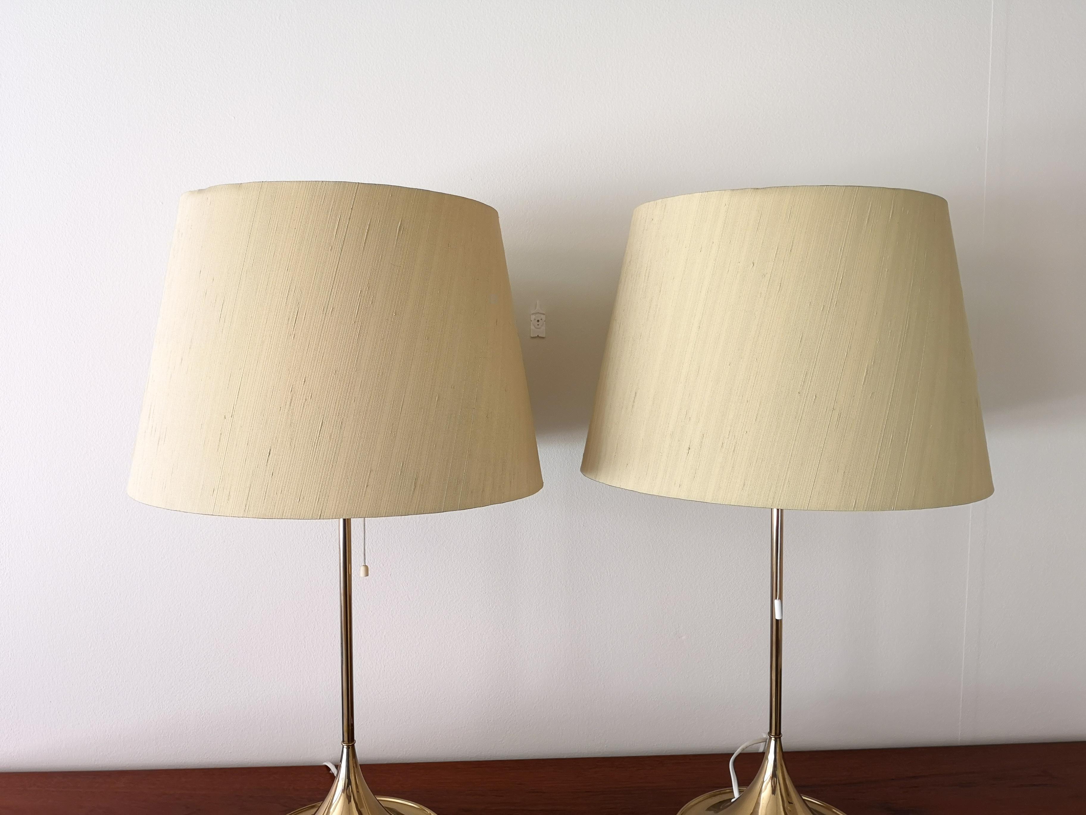 The table version of the iconic Bergboms design. Cast iron base finished in brass. This pair of table lamps will give that great look to a vintage home or a twist to the modern home. 

Very nice working condition.