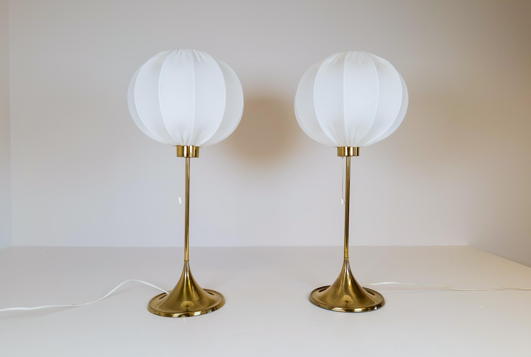 The table version of the iconic Bergboms design with all new cotton shades, made in Sweden. Cast iron base finished in brass. This pair of table lamps will give that great look to a vintage home or a twist to the modern home. This pair with cloud