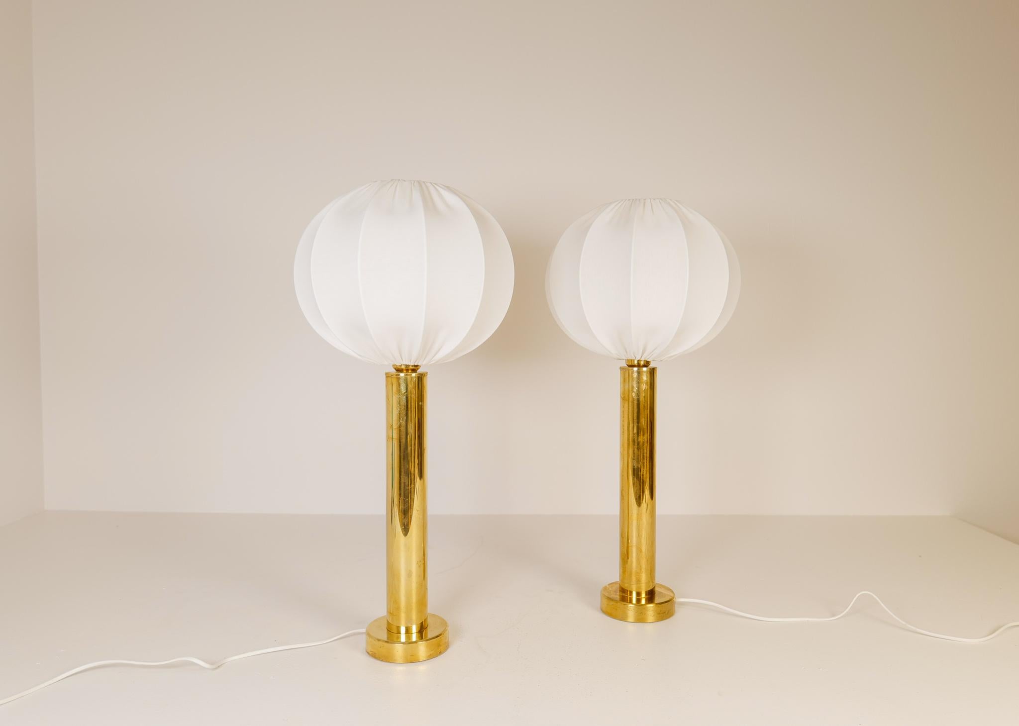 A pair of cylinder brass table lamps produced in Sweden during the late 1960s by Kosta Elarmatur. 

Good vintage condition with wear and age on the brass. All new high quality cotton shades made in Sweden. 

Dimensions: H 67 cm, Base Diameter 13