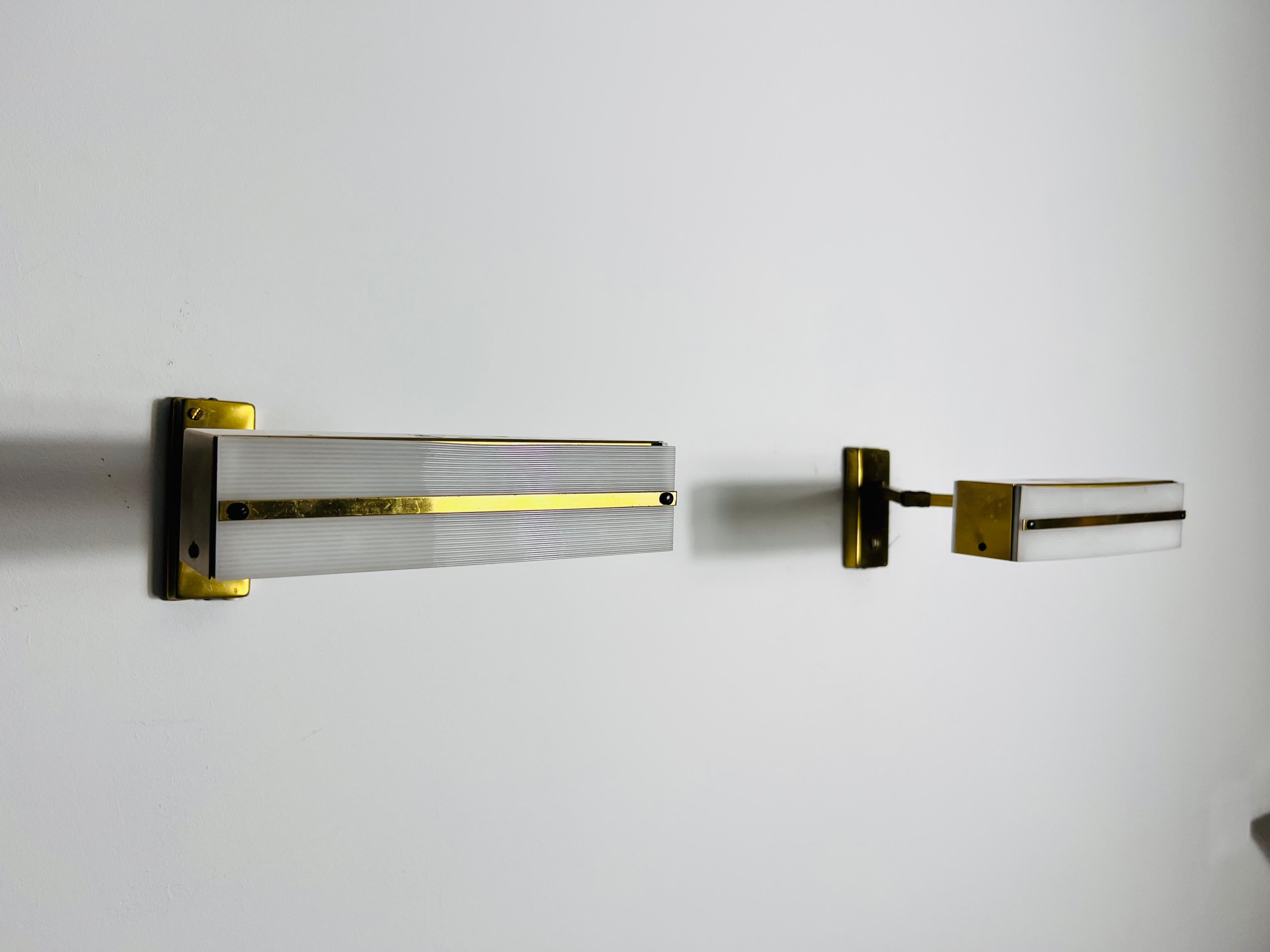 This pair of wall lamps, designed by Paul Neuhaus in the 1960s, showcases a harmonious blend of functionality and elegant design. The lamps feature a brass structure, including adjustable joints that allow you to customize the depth (15cm to 36cm)