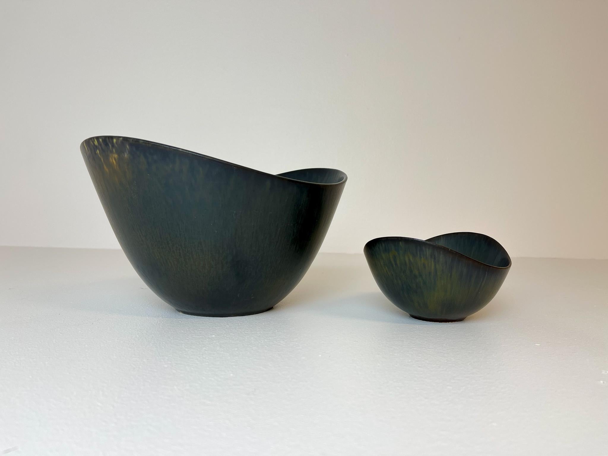 This set of two bowls contains the largest model of the AXK bowl and a ARO bowl, both manufactured in the 1950s at Rörstrand, designed by Gunnar Nylund.
The bowls has a wonderful green/black glaze and it lifts the shape of the bowl to a wonderful