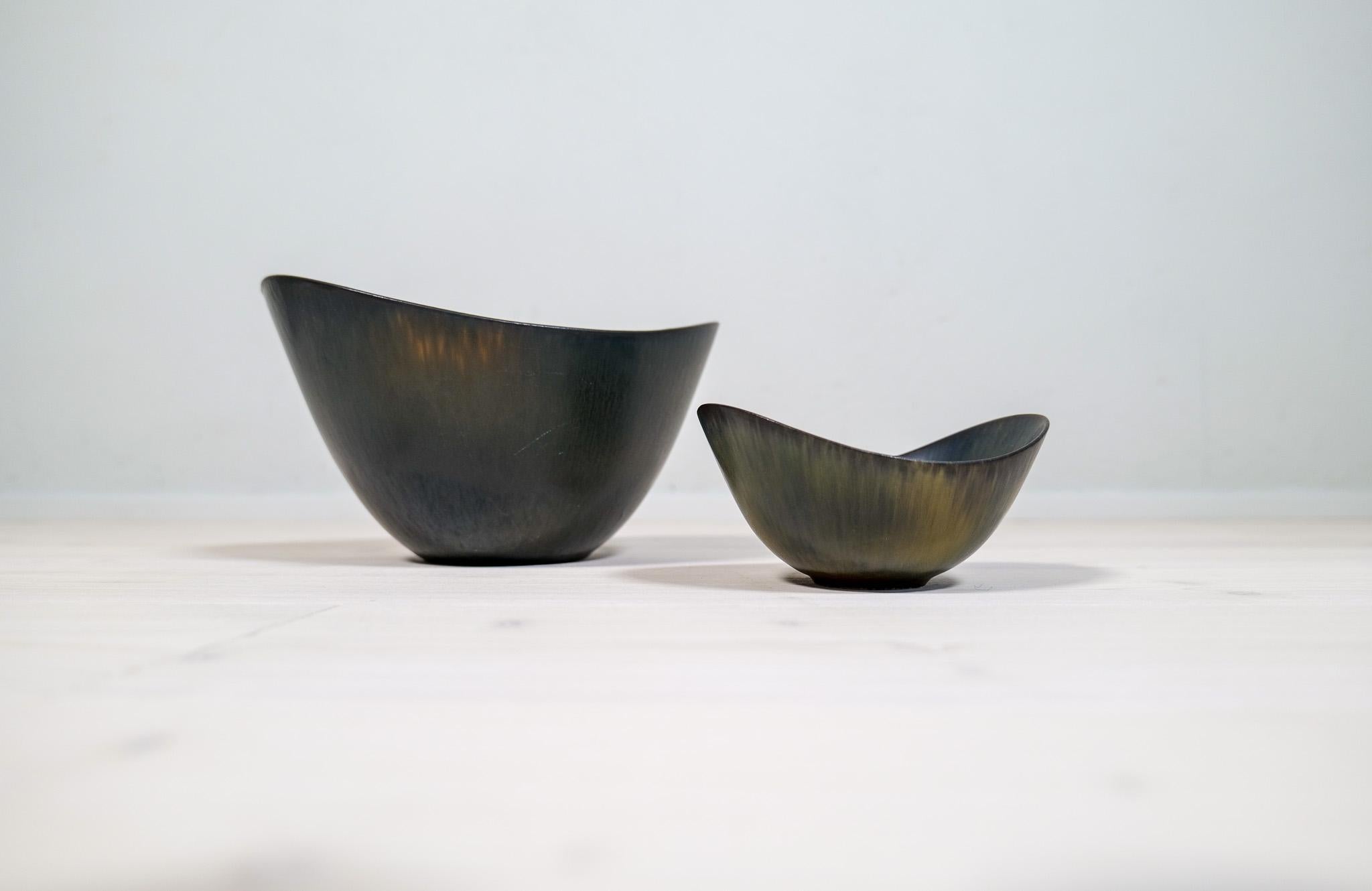 This set of two bowls contains the largest model of the AXK bowl and a ARO bowl, both manufactured in the 1950s at Rörstrand, designed by Gunnar Nylund.
The bowls has a wonderful green/black glaze and it lifts the shape of the bowls to a wonderful