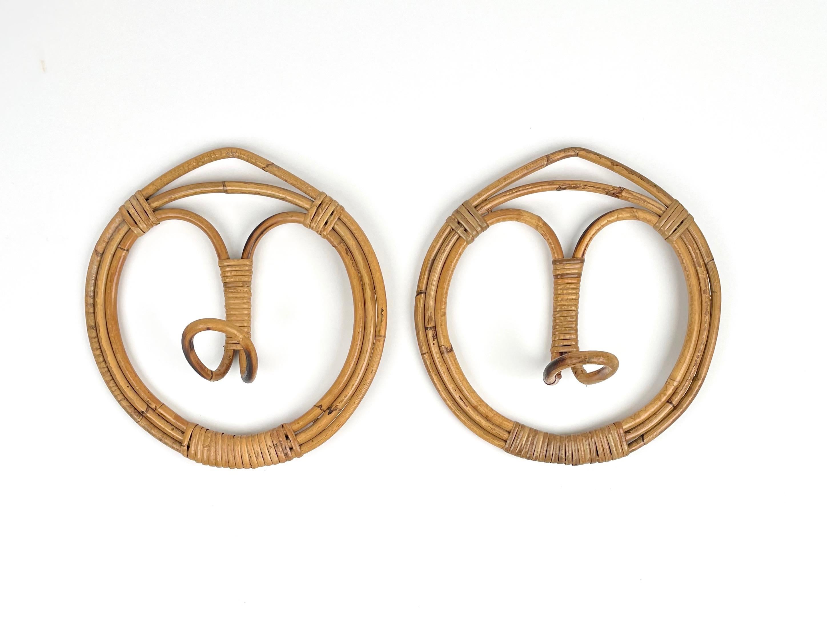 Pair of Midcentury modern round coat hangers in rattan and bamboo, single hook.

Made in Italy in the 1960s.