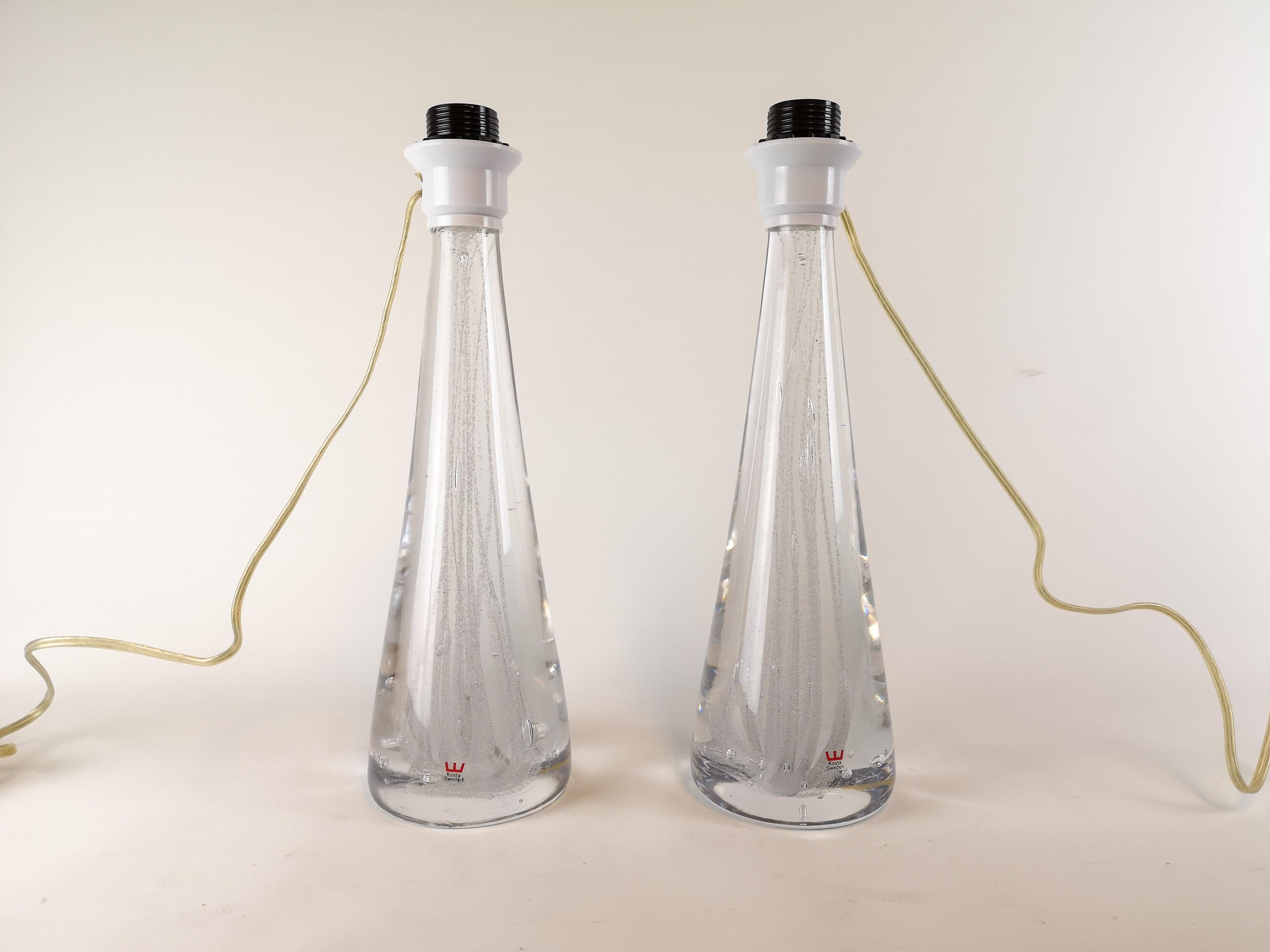 Pair of beautiful crystal glass table lamps by Vicke Lindstrand, organic conical in shape and with swirls of bubbles captured inside. 

Good working condition

H 58 with shades 38 without. D 35 with shades.