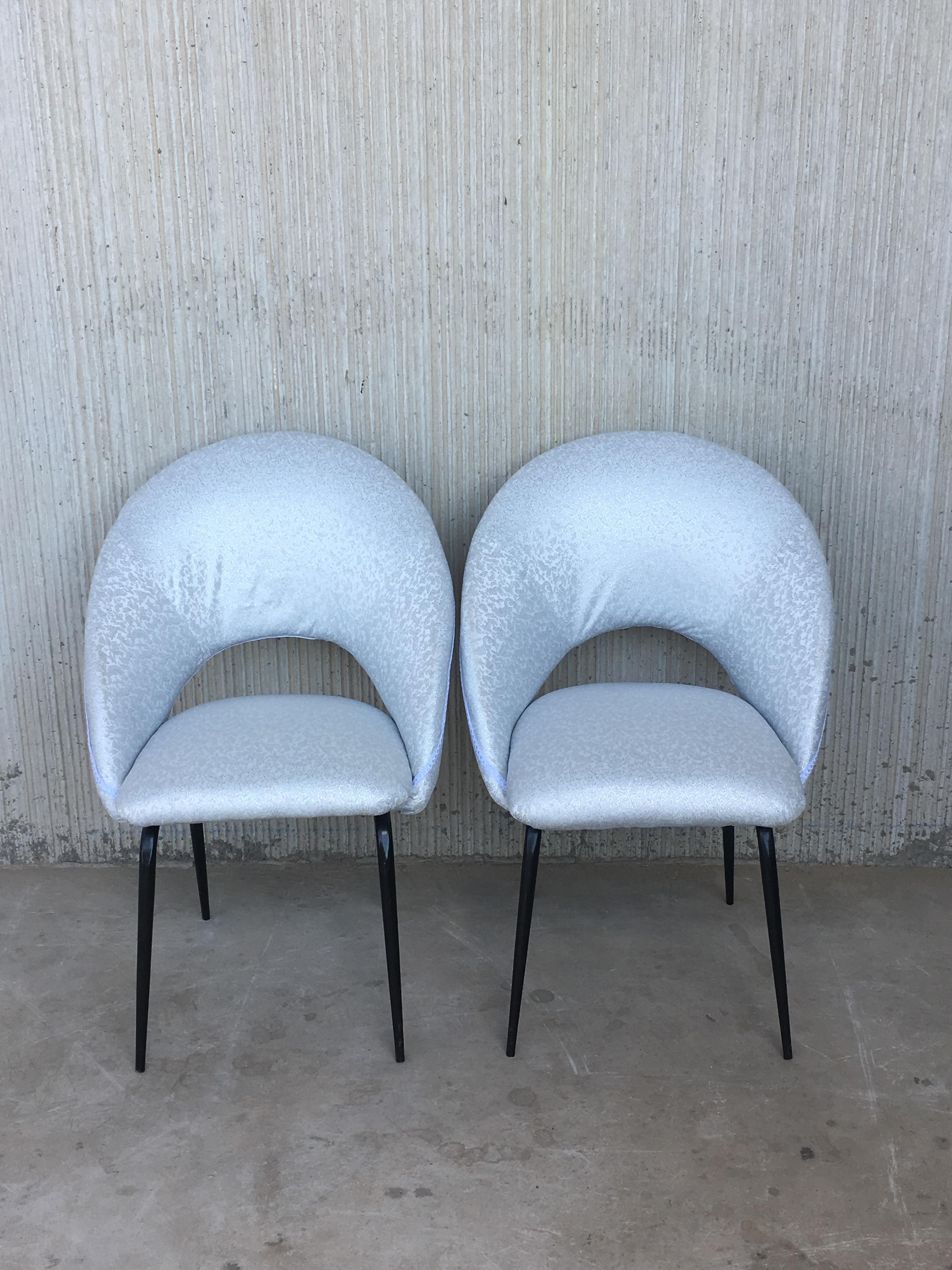 Midcentury pair of chairs on conical tapered legs with arched seats and arched backrest.