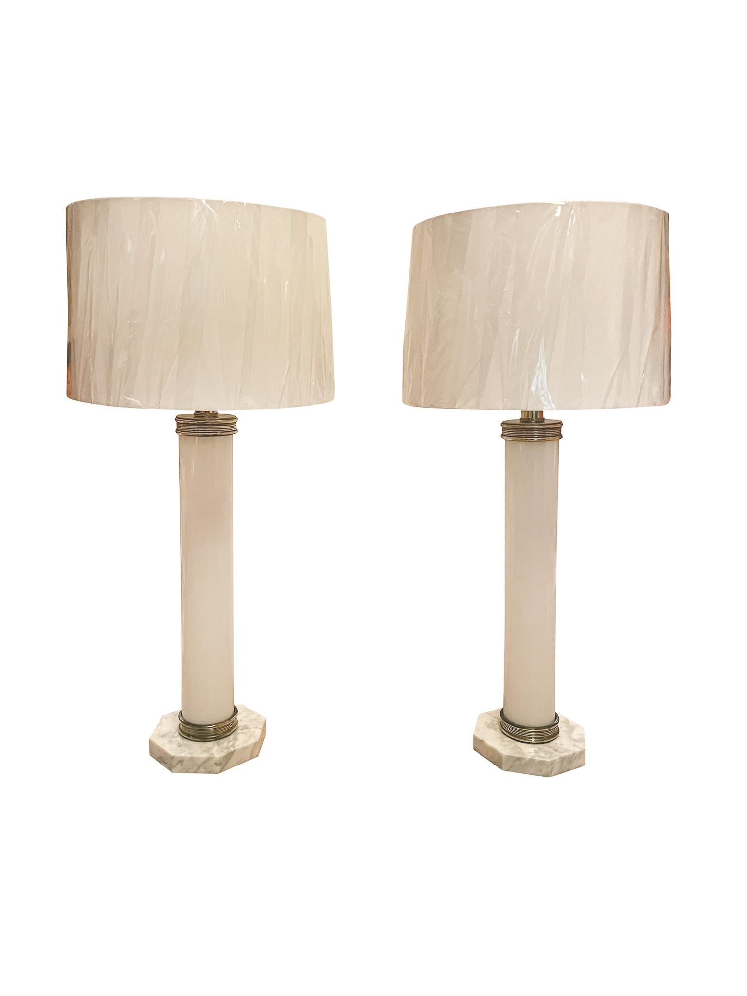 Fabricadas en la década de 1960, estas lámparas de mesa italianas constan de cuerpos de cristal blanco, bases octogonales de mármol y adornos de latón. Están recién recableadas y equipadas con nuevas cortinas de lino hechas a medida. Cada lámpara
