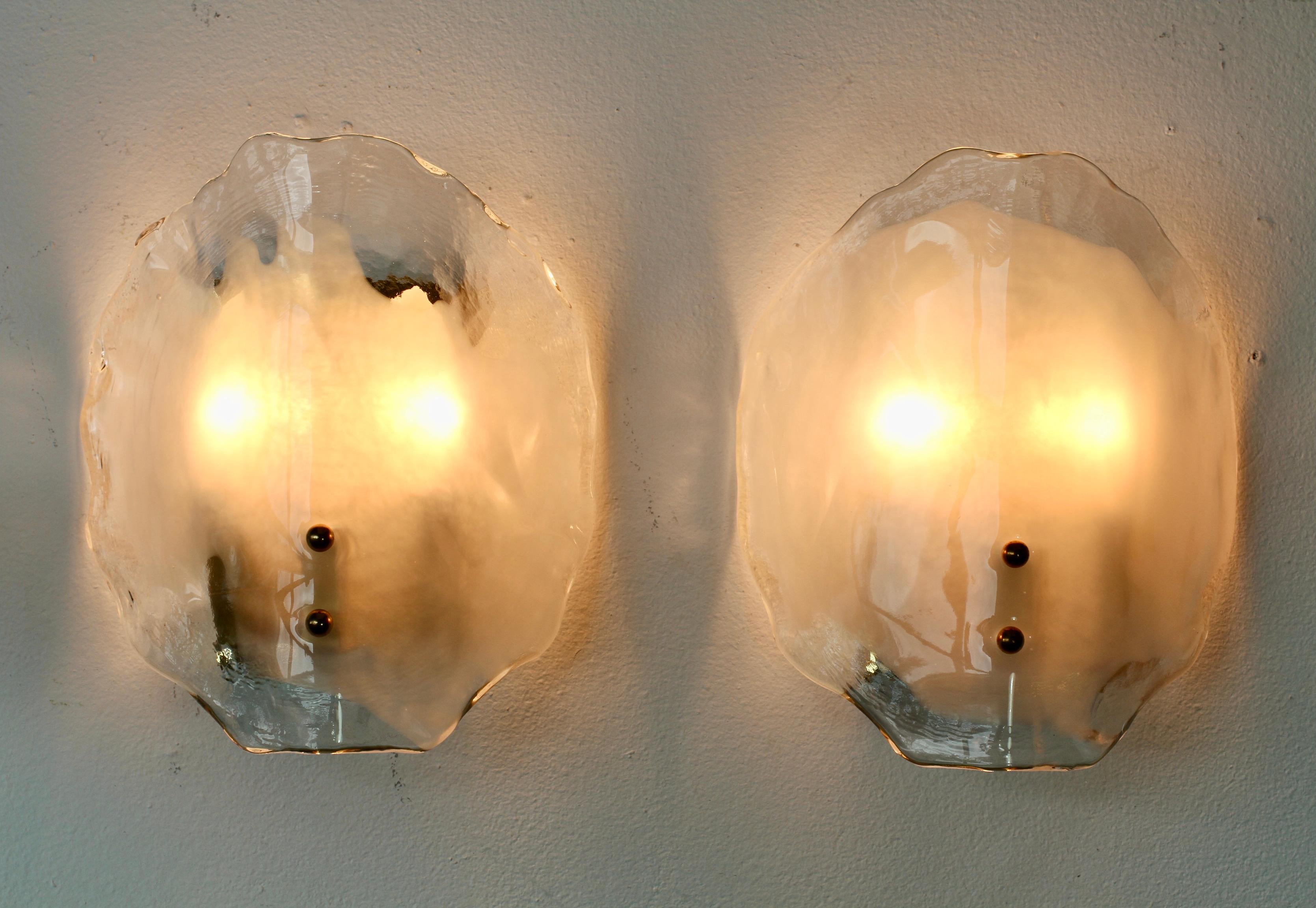 Rare Vintage Mid-Century Modern rare pair of organic brass, white and clear Murano glass double socketed wall lamps, lights or sconces by Austrian lighting manufacturer Kalmar, circa 1970s. Featuring two folded, curved 'flower petal' shaped glass