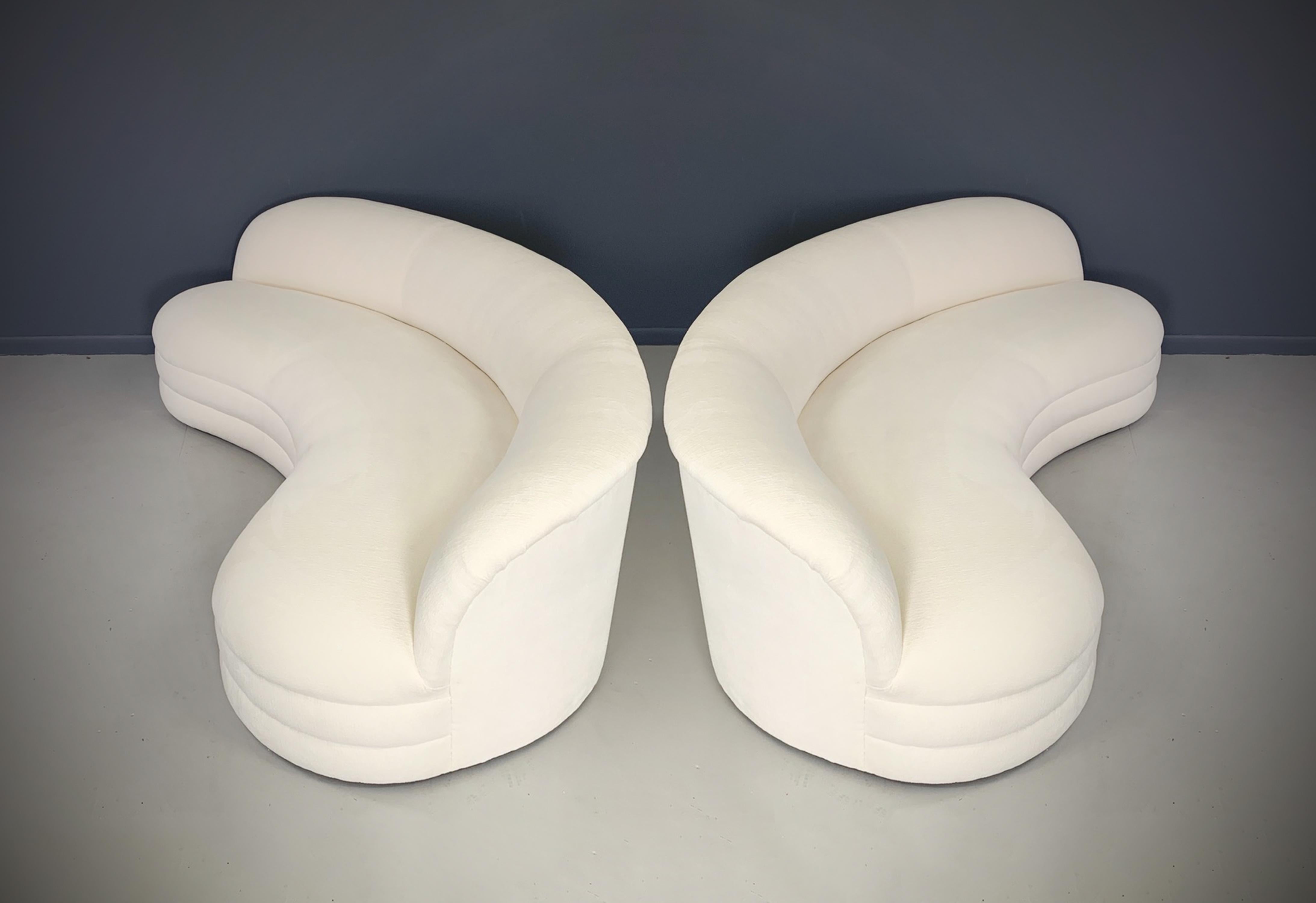 A pair of kidney-shaped sofas feature a nice sculptural modern design, with a curved arched back. These sofas are newly produced and have been handcrafted with a solid hardwood frame, manufactured in the United States with an 8 to 10 week