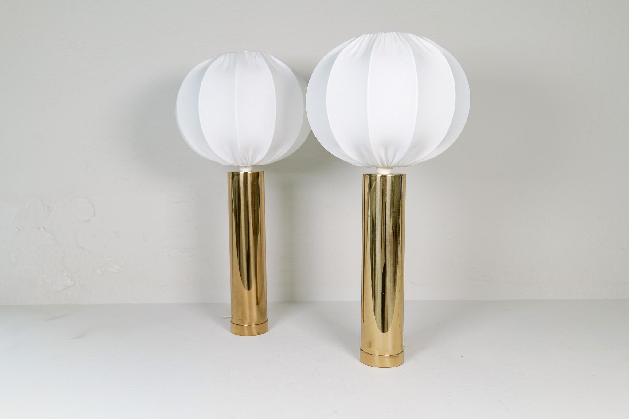 Large and heavy pair of cylinder-shaped table lamps in brass. Bergboms design with all new cotton shades, made in Sweden. Cast iron base finished in brass. This pair of table lamps will give that great look to a vintage home or a twist to the modern