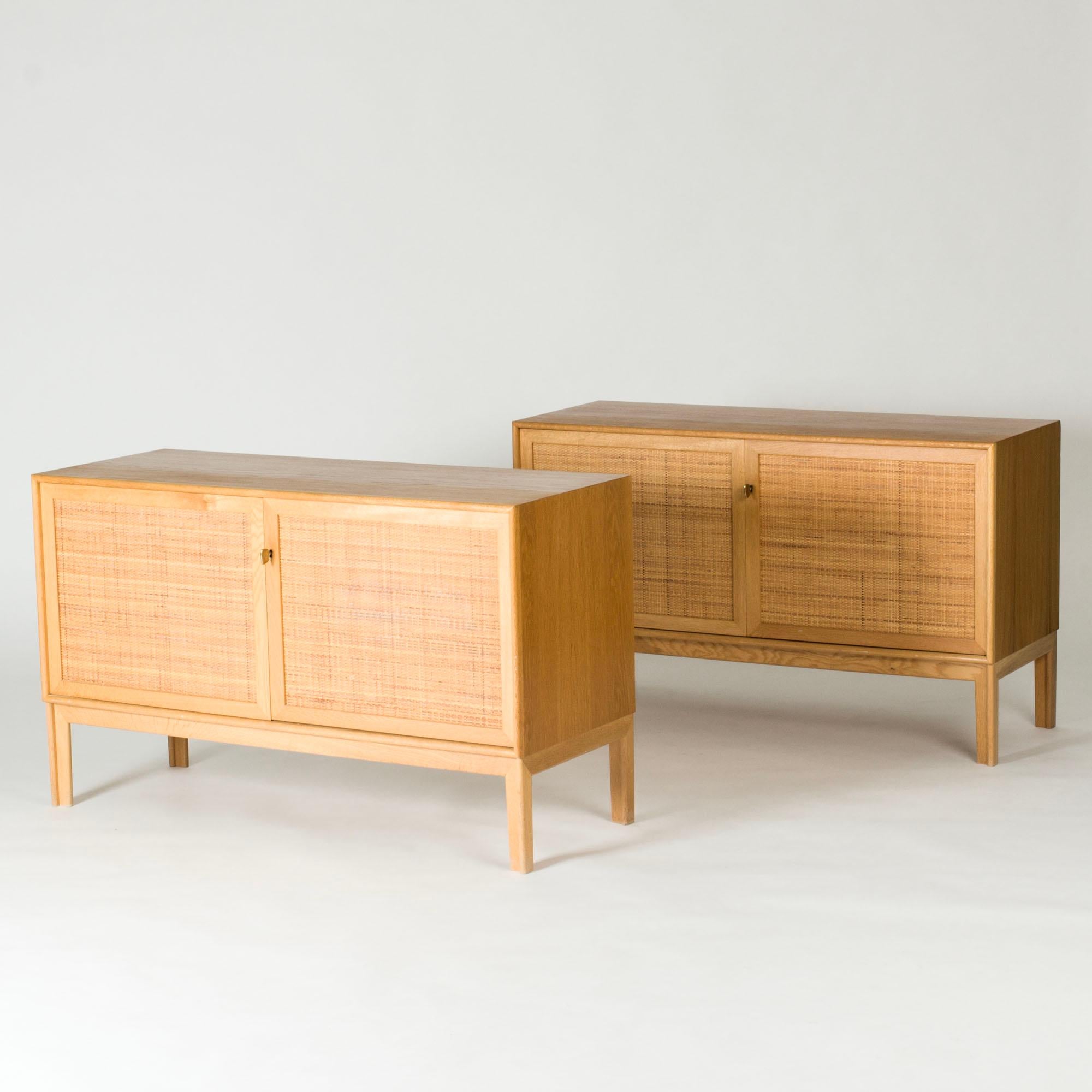 Coppia di credenze in Oak con bellissimi frontali in rattan, disegnate da Alf Svensson. Due ripiani all'interno di ogni credenza separati da una parete al centro. Chiavi in ottone grandi e fresche e gambe ben scolpite.