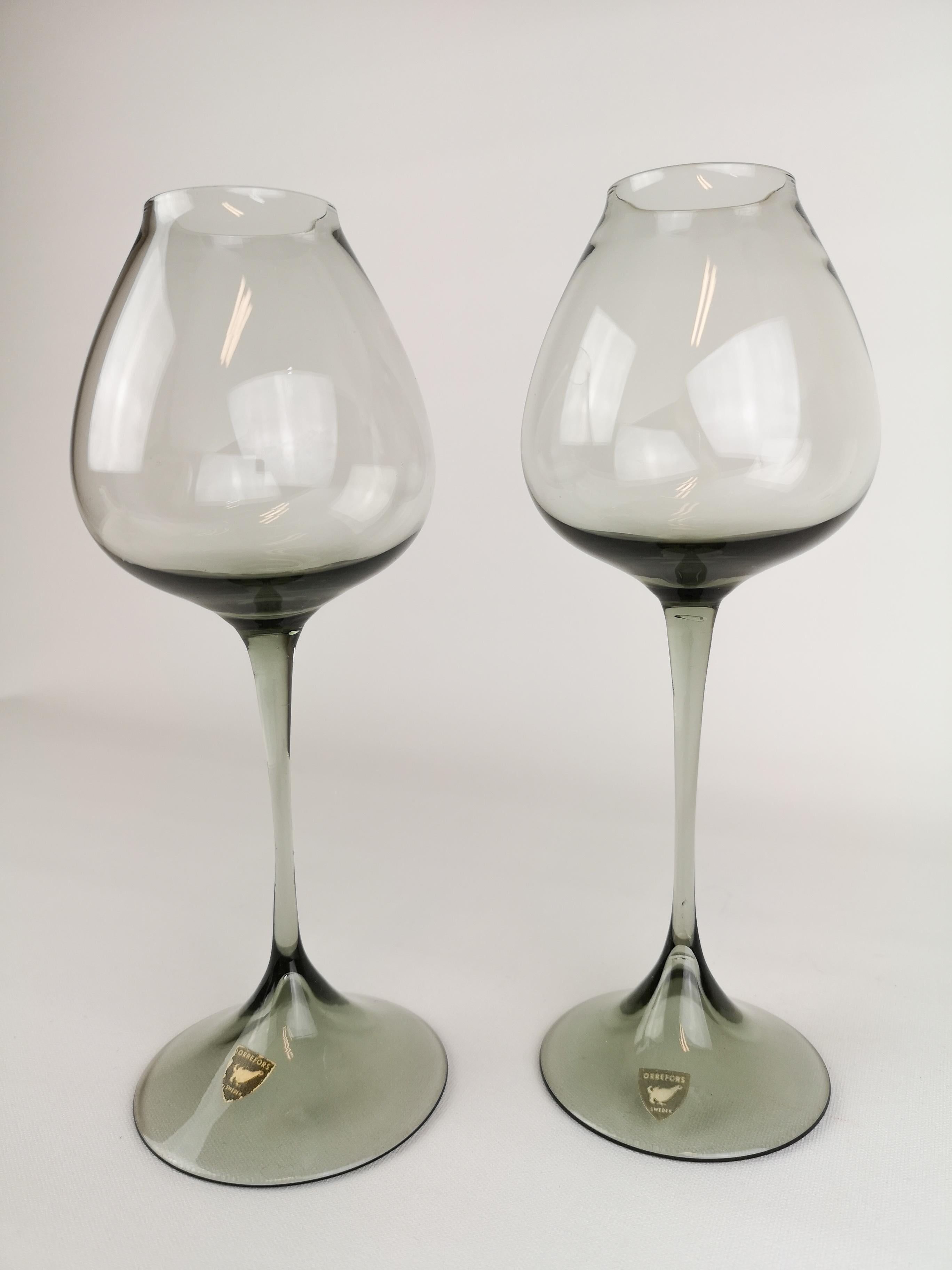 Wonderful pair of tulip glasses in grey tinted design. Manufactured at Orrefors in Sweden and design by Nils Landberg.

Good vintage condition and both are wearing a label.

Measures: H 22 D 8 cm.