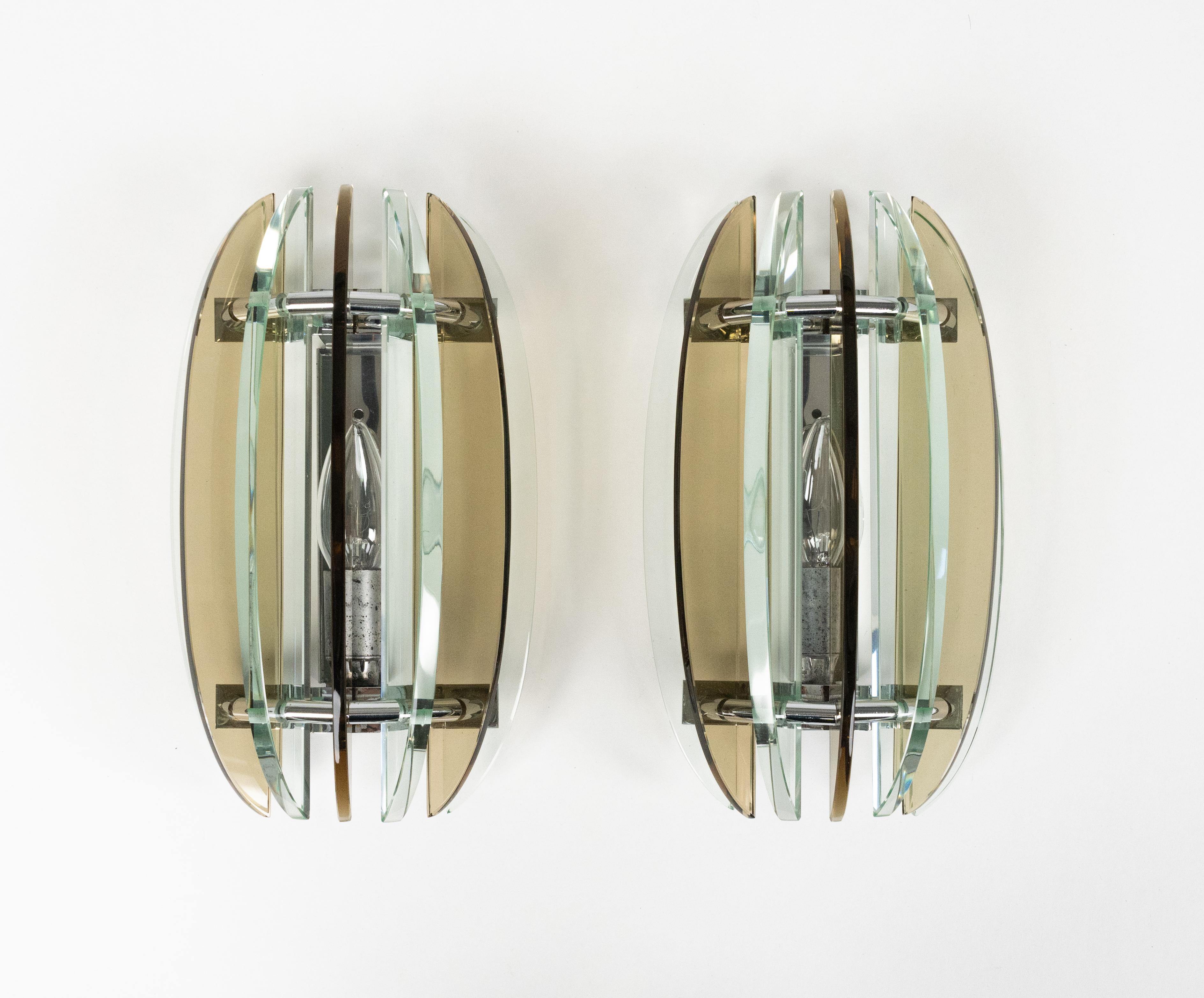 Midcentury beautiful pair of wall sconces in colored glass ( green and smoked) and chrome by Veca.  

Made in Italy in the 1970s.  

The original label is still attached as shown in the pictures.

They are wired for the United States or Europe and