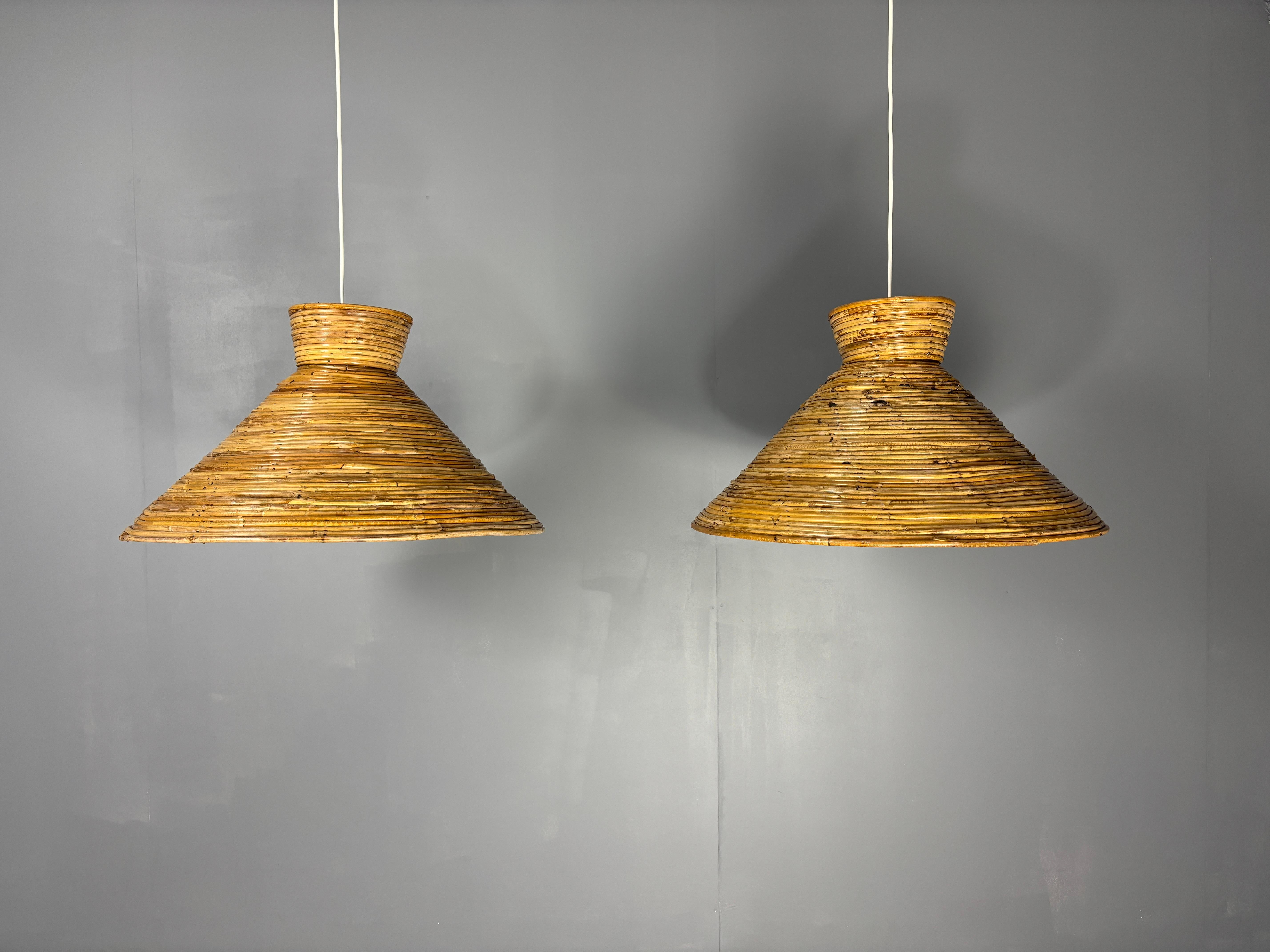 Pareja de colgantes grandes ( 62 cm ) de ratán lápiz de mediados de siglo, Italia años 70. Este conjunto está en un estado rústico vintage, todo el ratán se ha unido a martillazos con los clavitos como puede verse en las fotos. Tienen un racor