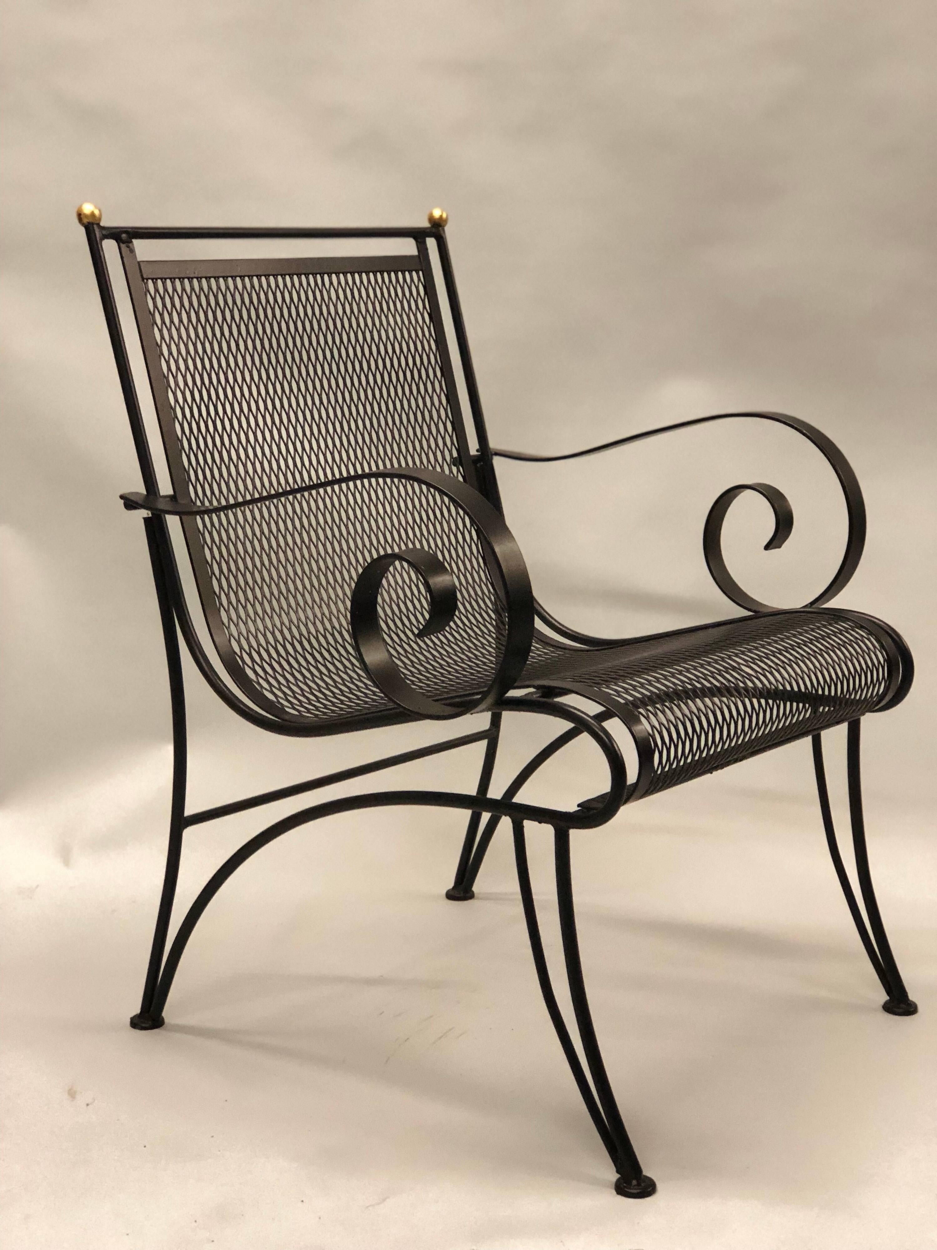 Elegant pair of French Mid-Century Modern neoclassical wrought iron armchairs attributed to René Prou.

The chairs are enameled black and feature a minimal transparent structure, front and rear saber legs and are finished with a pair of gilt ball