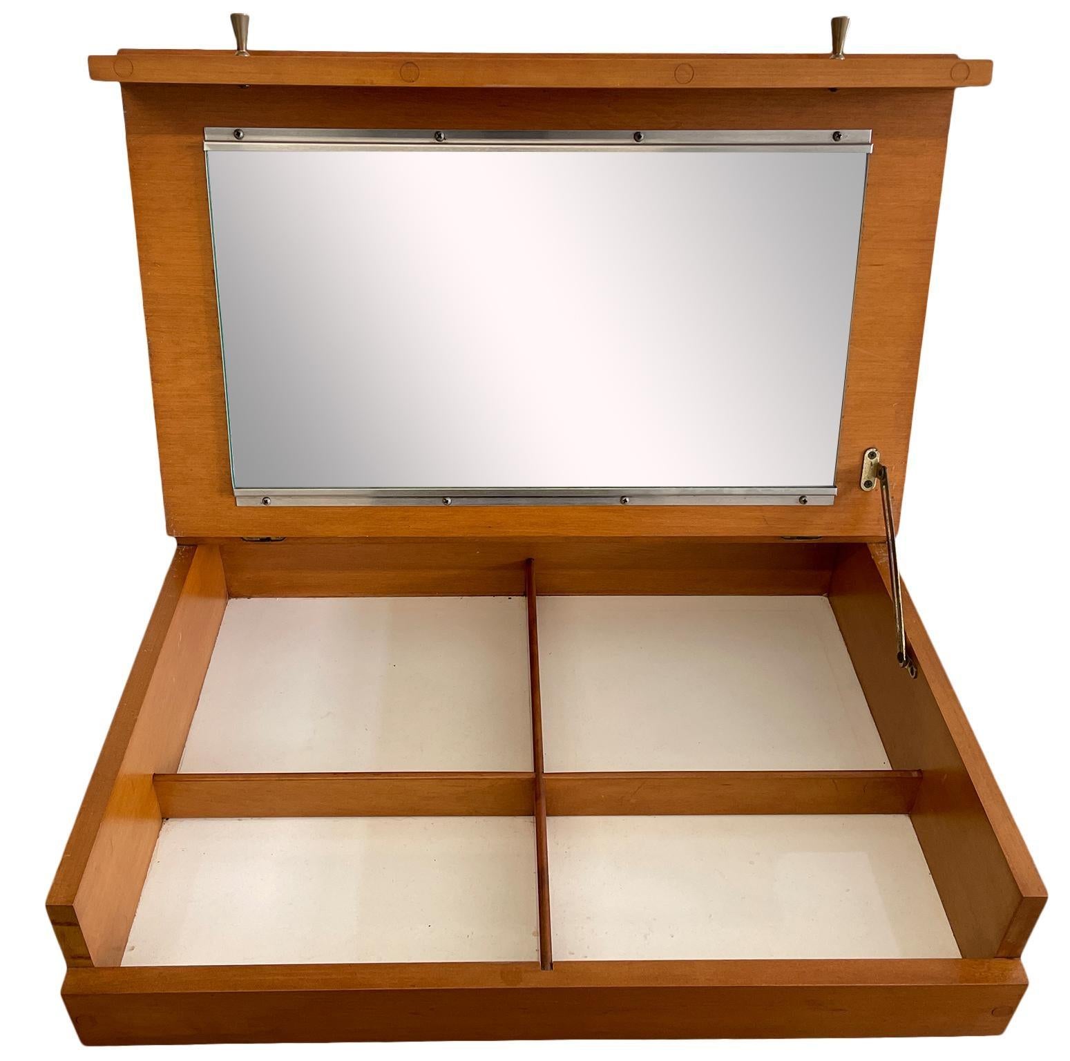 Rare petit miroir de courtoisie #1559 de Paul McCobb en érable massif avec finition Tobacco Blonde. Construction de très haute qualité avec des poignées en laiton d'origine. Conçue pour être suspendue entre les sommets de deux commodes ou simplement