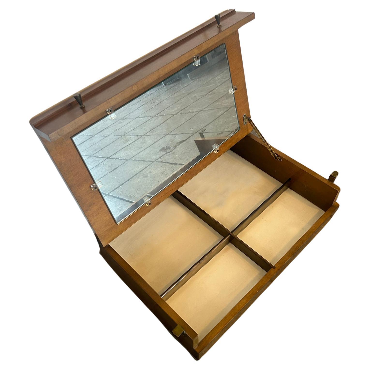 Raro specchio per vanità Paul McCobb #1559, piccolo e ribaltabile, costruito in acero massiccio con finitura in noce marrone scuro. Costruzione di altissima qualità con tiretti originali in ottone. È stato realizzato per essere appeso tra i piani di