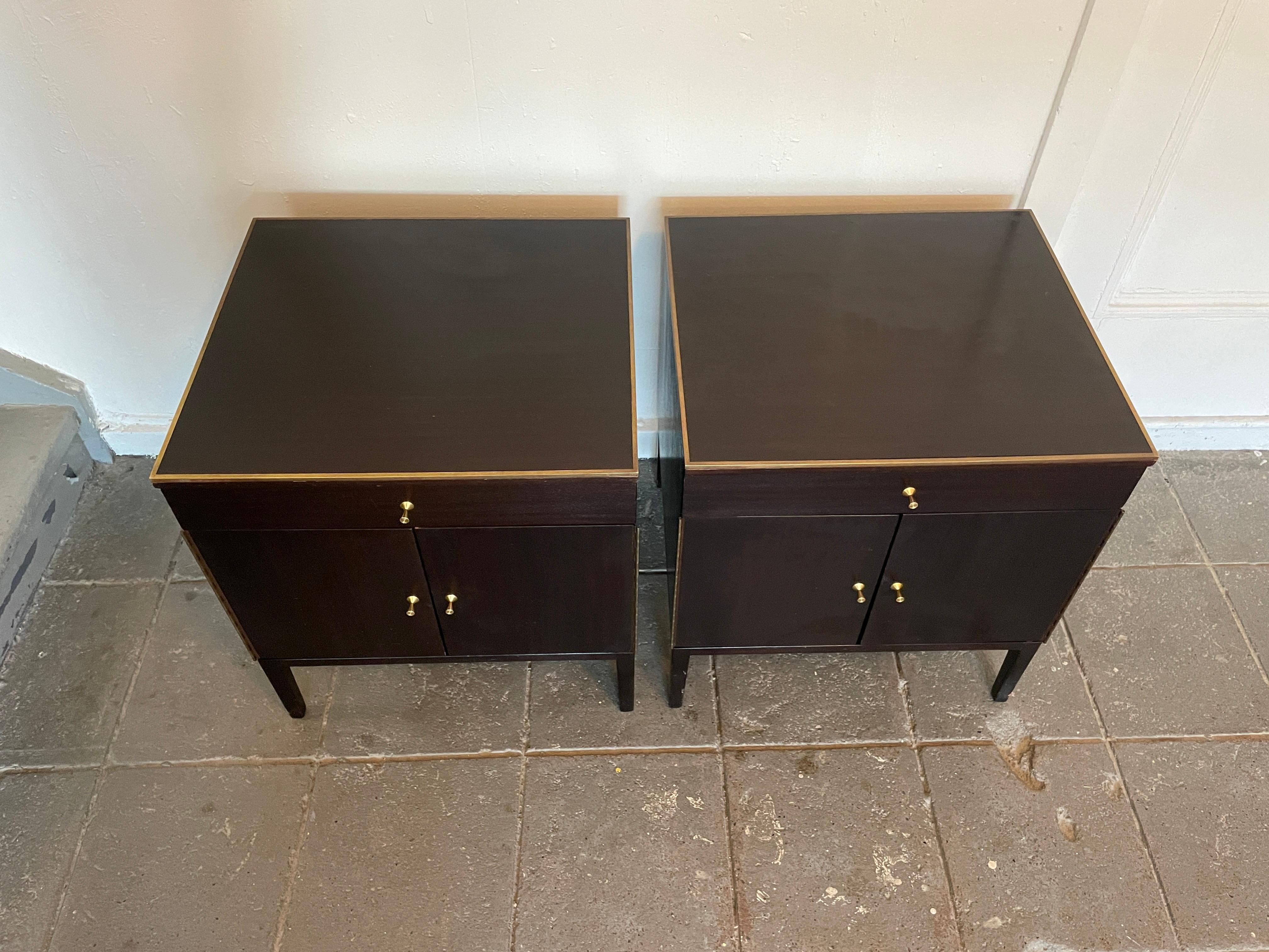 Beautiful pair of Paul McCobb 1960s Production #7700 dark mahogany nightstands end tables with leather lined drawers and brass trim. Has single-drawer with lower cabinet that has 1 adjustable shelf. Solid Brass top trim, hinges and knobs - Original