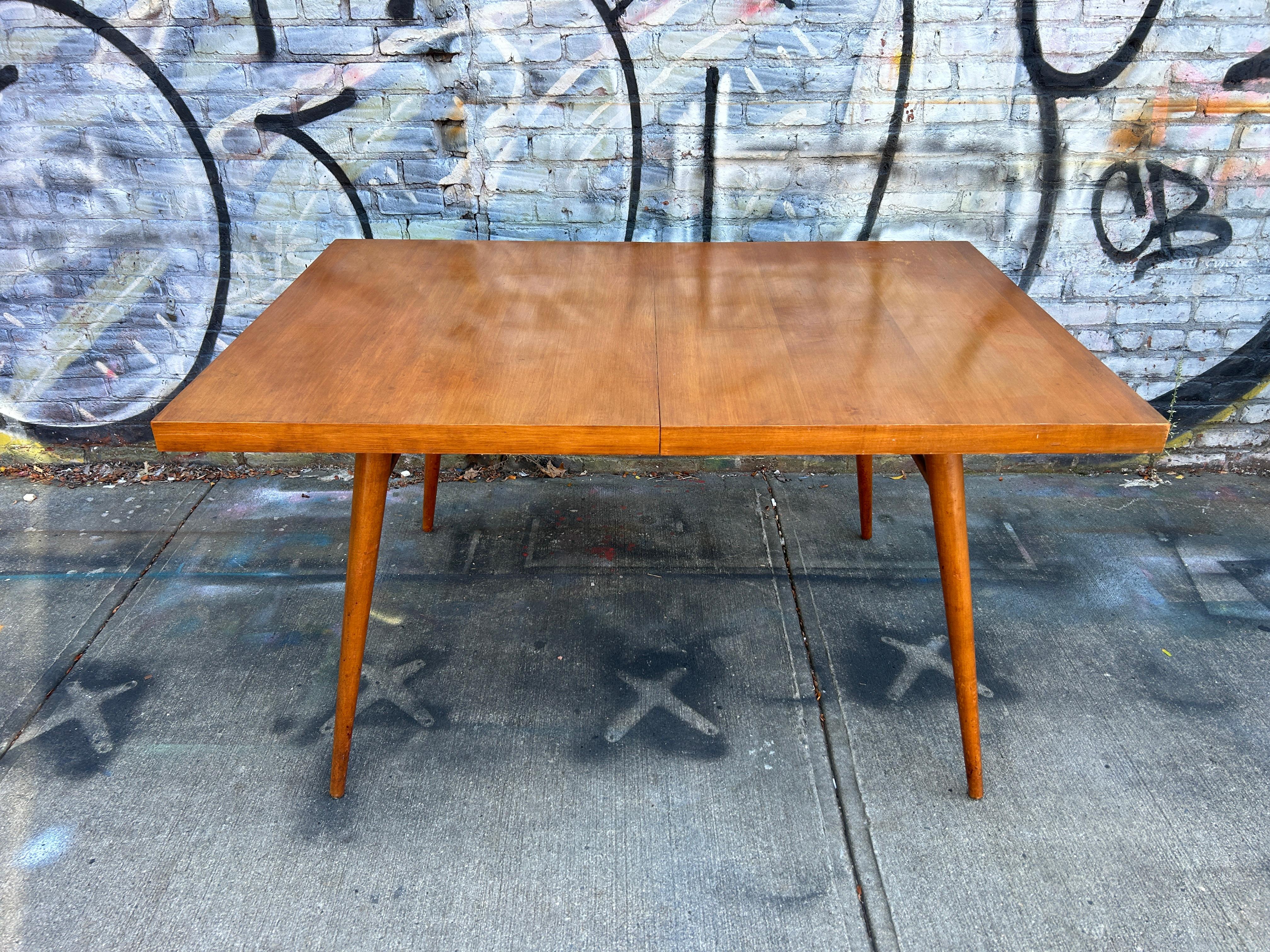 Beautiful early 1950s Paul McCobb maple dining table #1522 with 4 tapered legs and dowel supports. Original maple tabletop with a blonde tobacco finish in good vintage condition. Legs unbolt - easy to move. You are buying (1) dining table with (2)