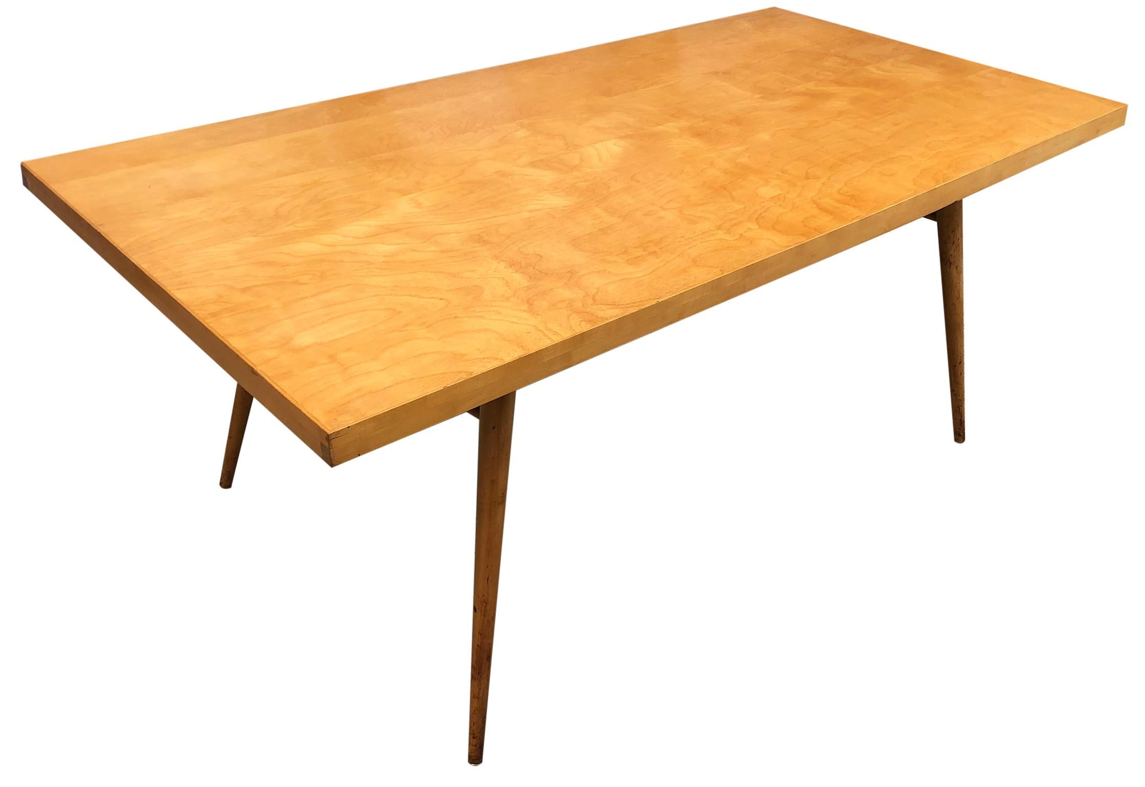 Beautiful early 1950s Paul McCobb solid maple dining table #1522 with 4 tapered legs and dowel supports. Rare solid (1) section maple tabletop with a blonde finish in great vintage condition. Legs unbolt - easy to move. You are buying (1) dining