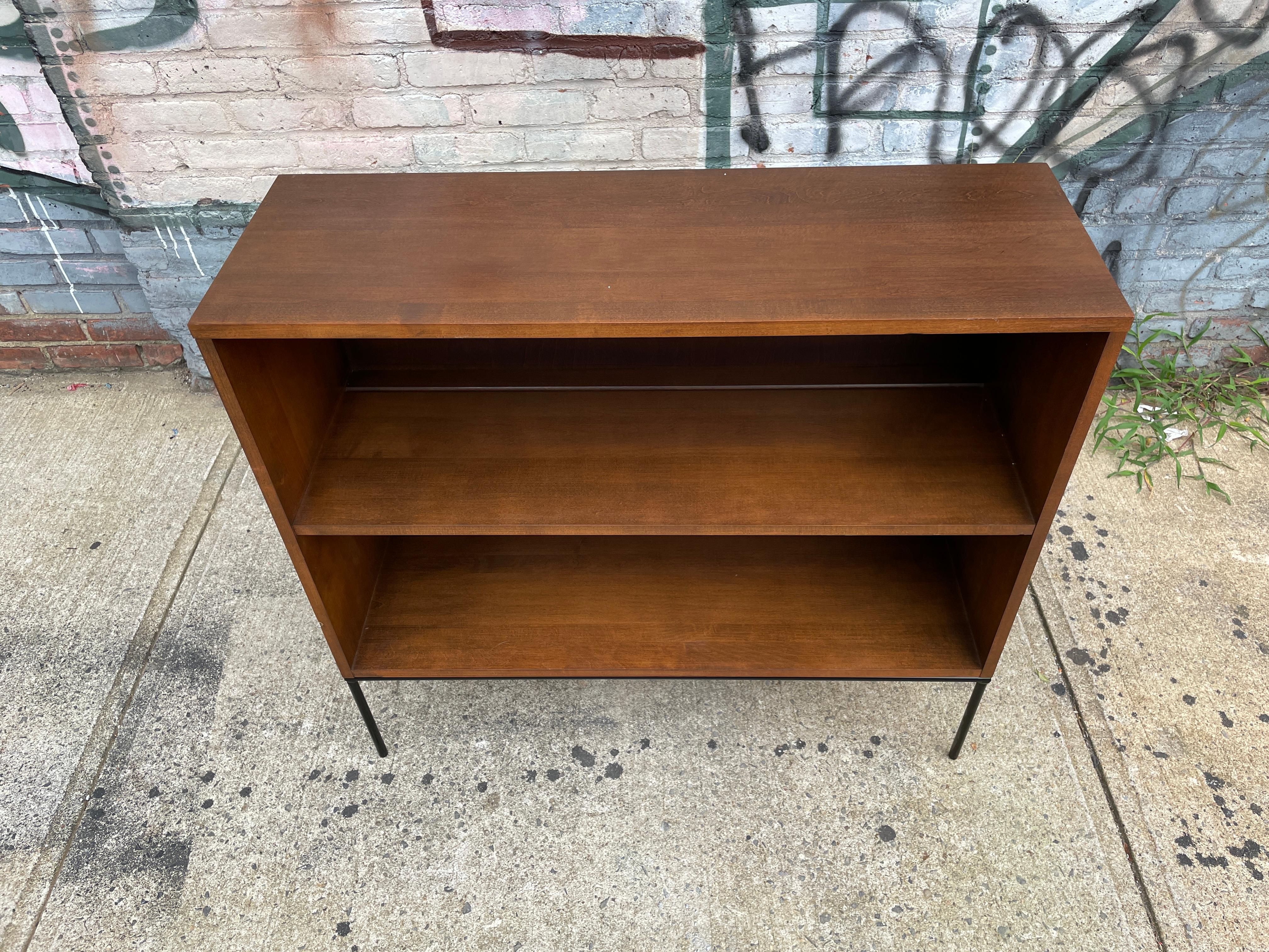 Vintage midcentury Paul McCobb single bookcase #1516 solid maple with original walnut finish on an Iron base. Beautiful bookcase by Paul McCobb circa 1950s Planner Group, single center shelf fixed position, solid maple construction. Original backing