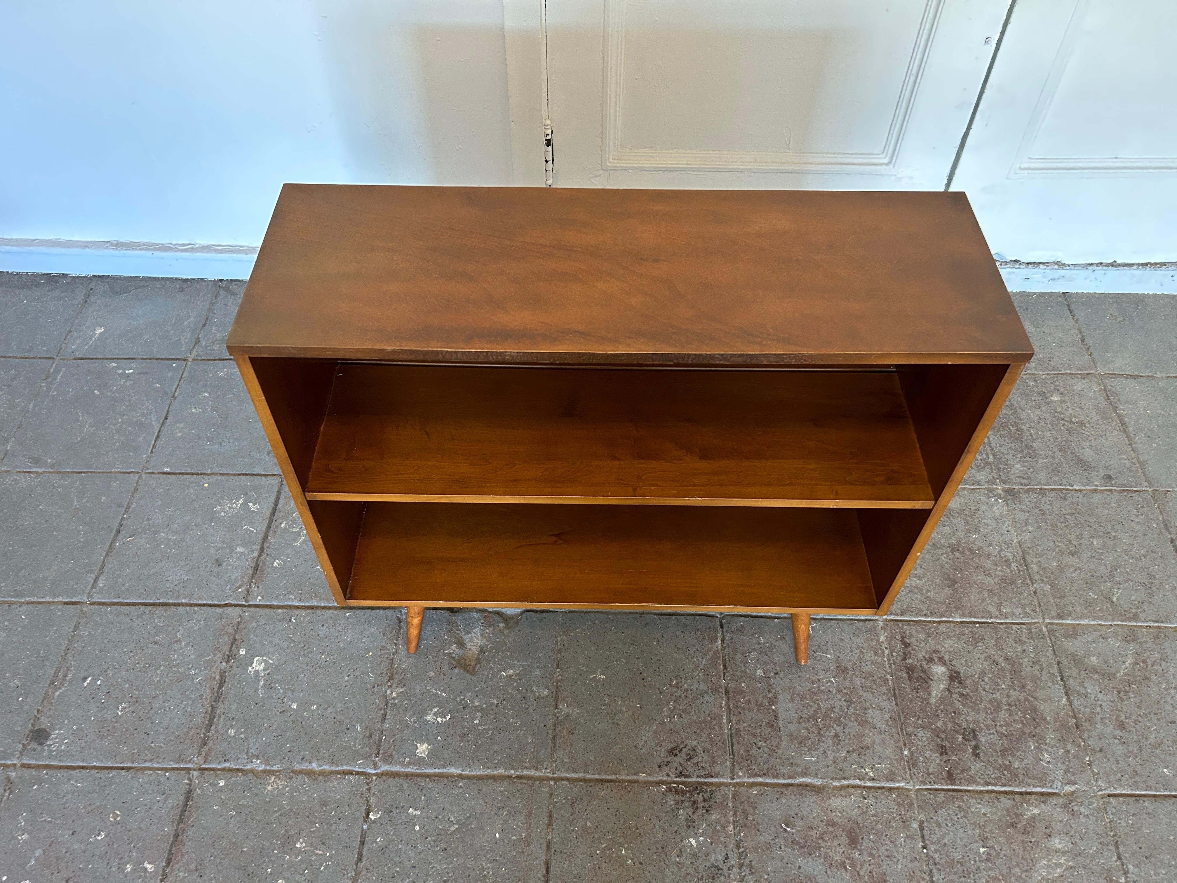 Vintage midcentury Paul McCobb single bookcase #1516 solid maple with original walnut finish on 4 tapered legs. Beautiful bookcase by Paul McCobb circa 1950s Planner Group, single center shelf fixed position, solid maple construction. Original