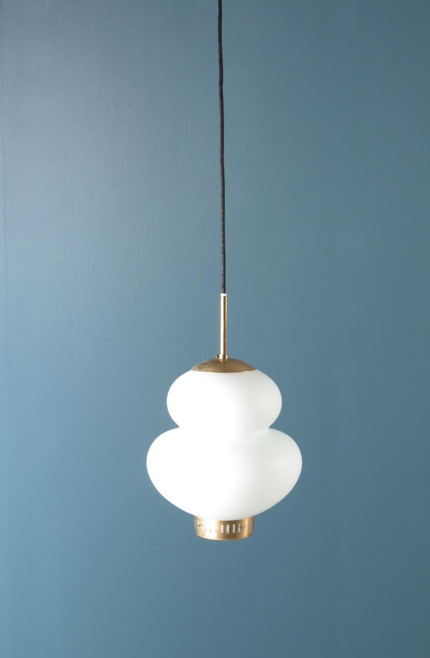 Ciondolo in vetro e ottone patinato disegnato da Bent Karlby per Lyfa. Prodotto in Danimarca, circa 1955, ottime condizioni originali.
 