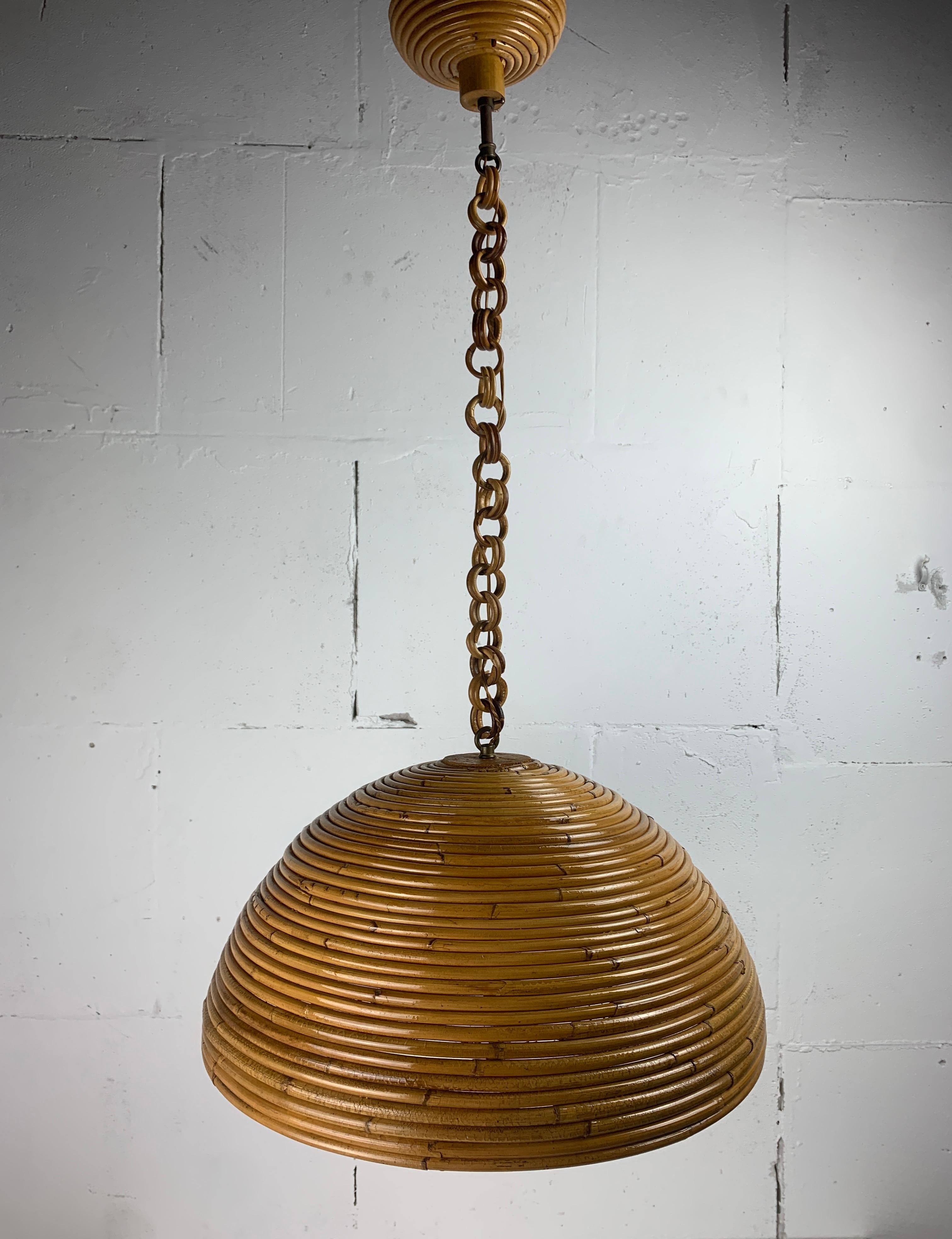 Una meravigliosa lampada a sospensione in rattan e vimini a matita o in canna spaccata, Italia anni '70. L'ancia spaccata è ancora in ottime condizioni e ha ottenuto una bella patina profonda. Attualmente la lampada può essere appesa fino a 85 cm