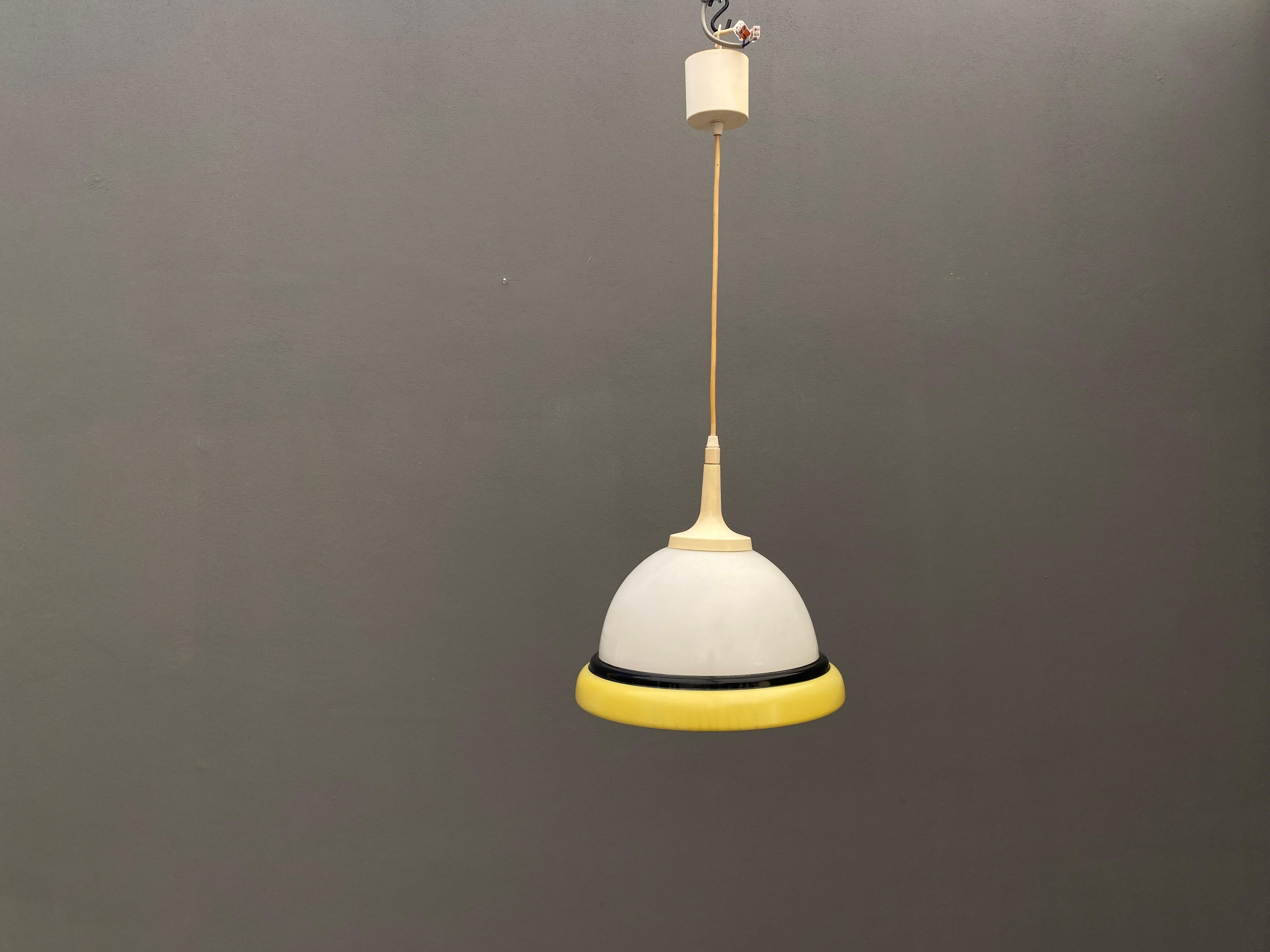 Una lampada a sospensione dal design senza tempo, adatta a vari ambienti.  È stato prodotto nell'Europa dell'Est negli anni '60. La struttura combina elementi chiari con un accento nero, creando un sottile contrasto visivo. Con dimensioni di 77 cm