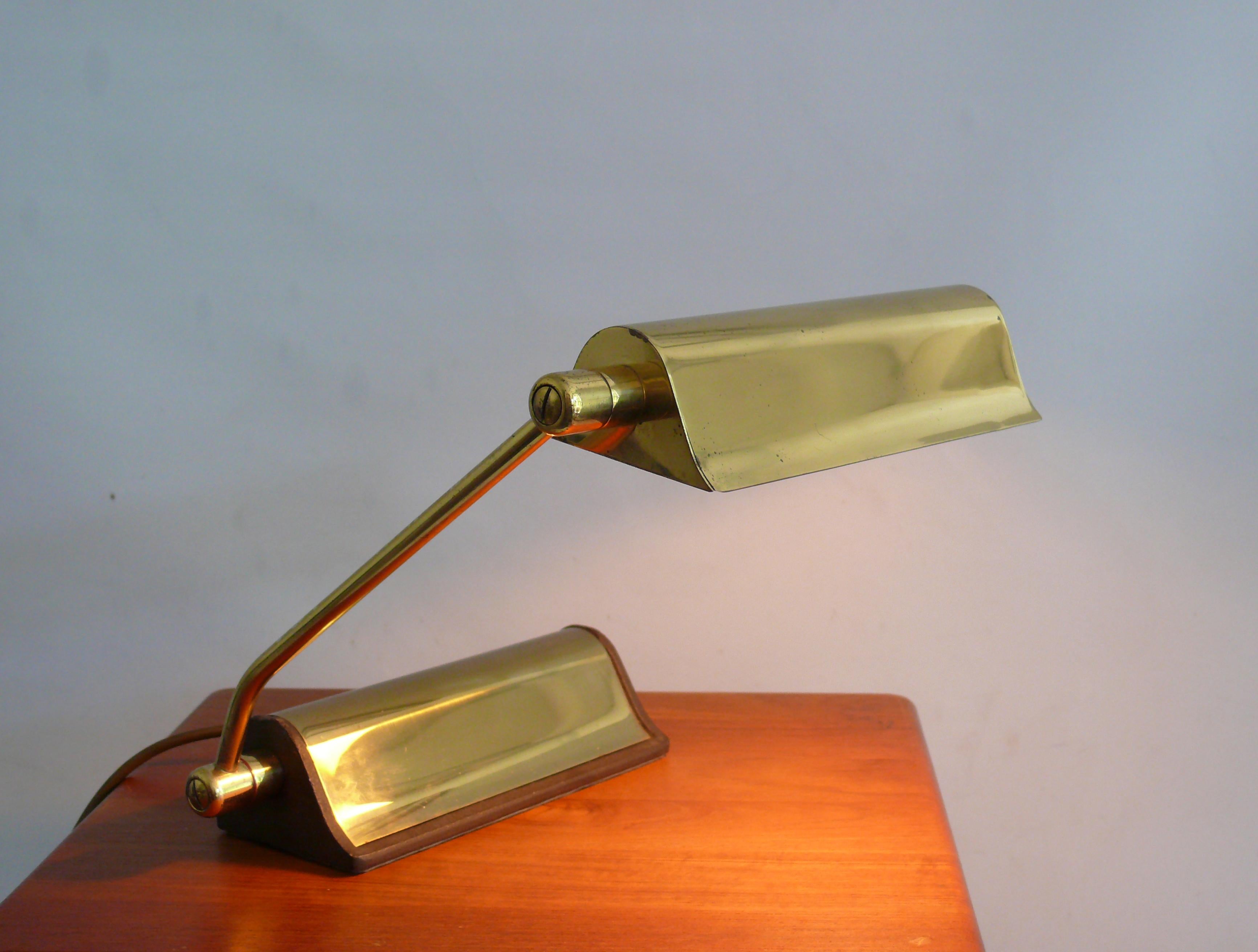 Lampada da pianoforte in ottone molto solida e pesante, degli anni '60-'70 circa, di Hillebrand, Germania, modello 170 387. La lampada è realizzata in ottone lucido con una pesante base in ghisa. L'ombrello e il braccio possono essere regolati. La