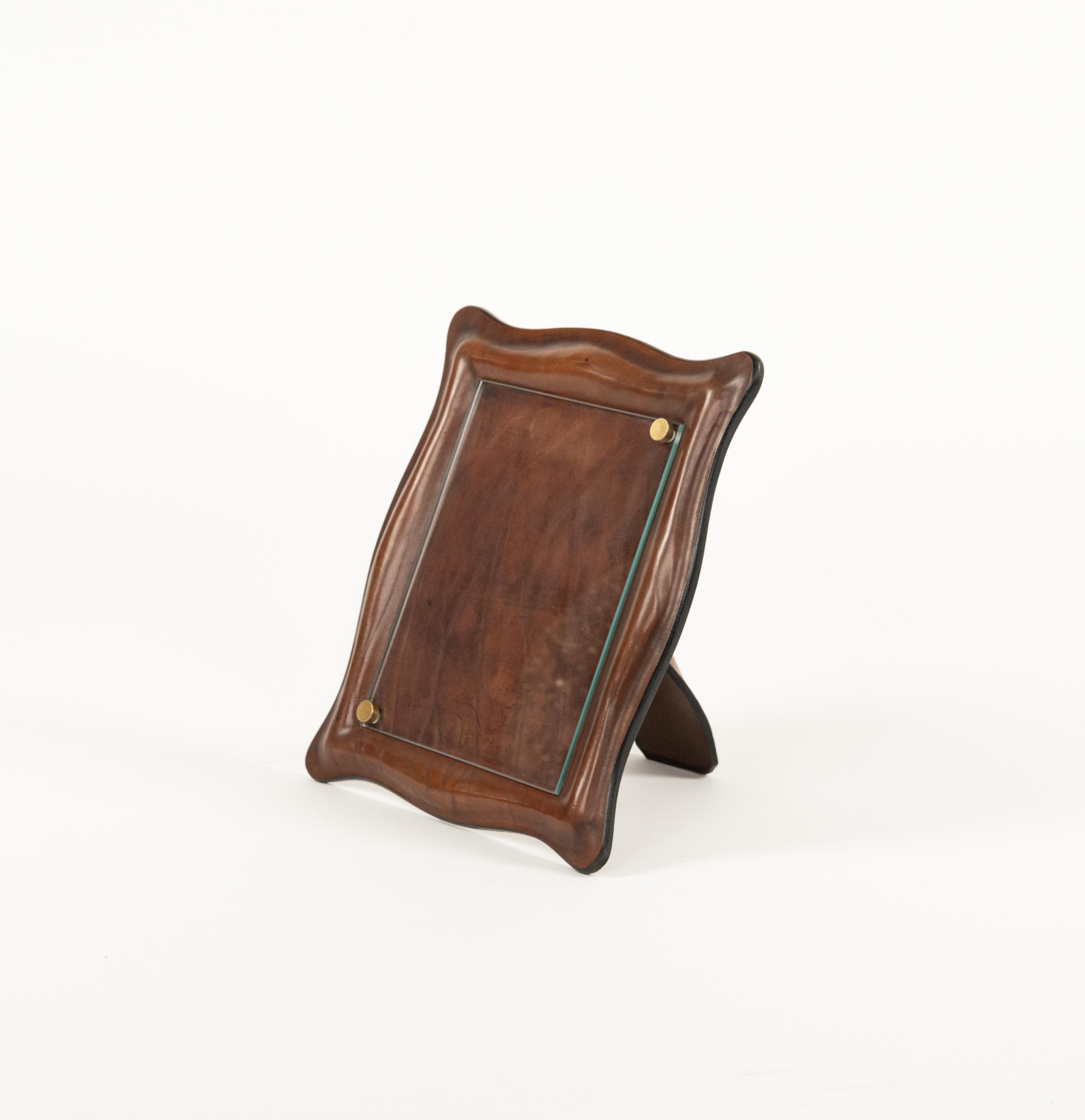 Cadre photo du milieu du siècle en cuir brun courbé, verre et détails en laiton.

Fabriqué en Italie dans les années 1970.

Objet de bureau parfait ou idée de cadeau.