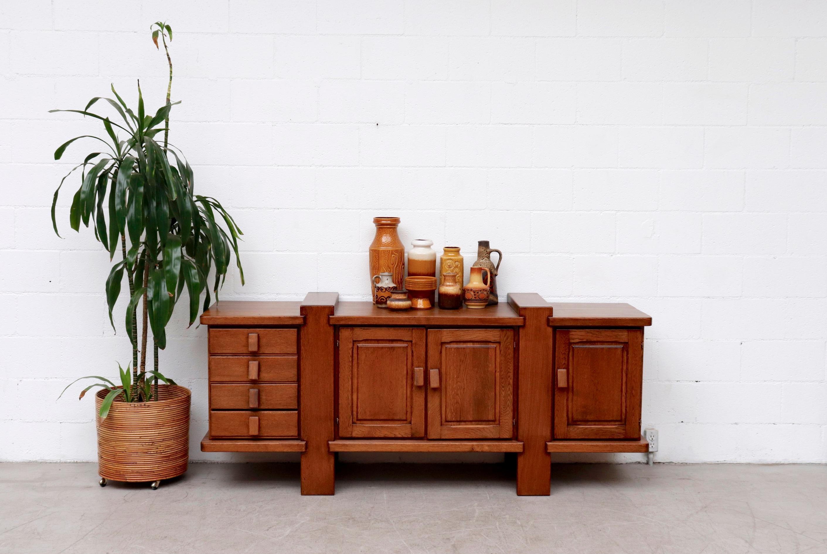 Beautiful mid-century Pierre Chapo style oak credenza with stacked drawers and thick carved pulls. Rustic style and craftsmanship in original condition with wear consistent with its age and usage.