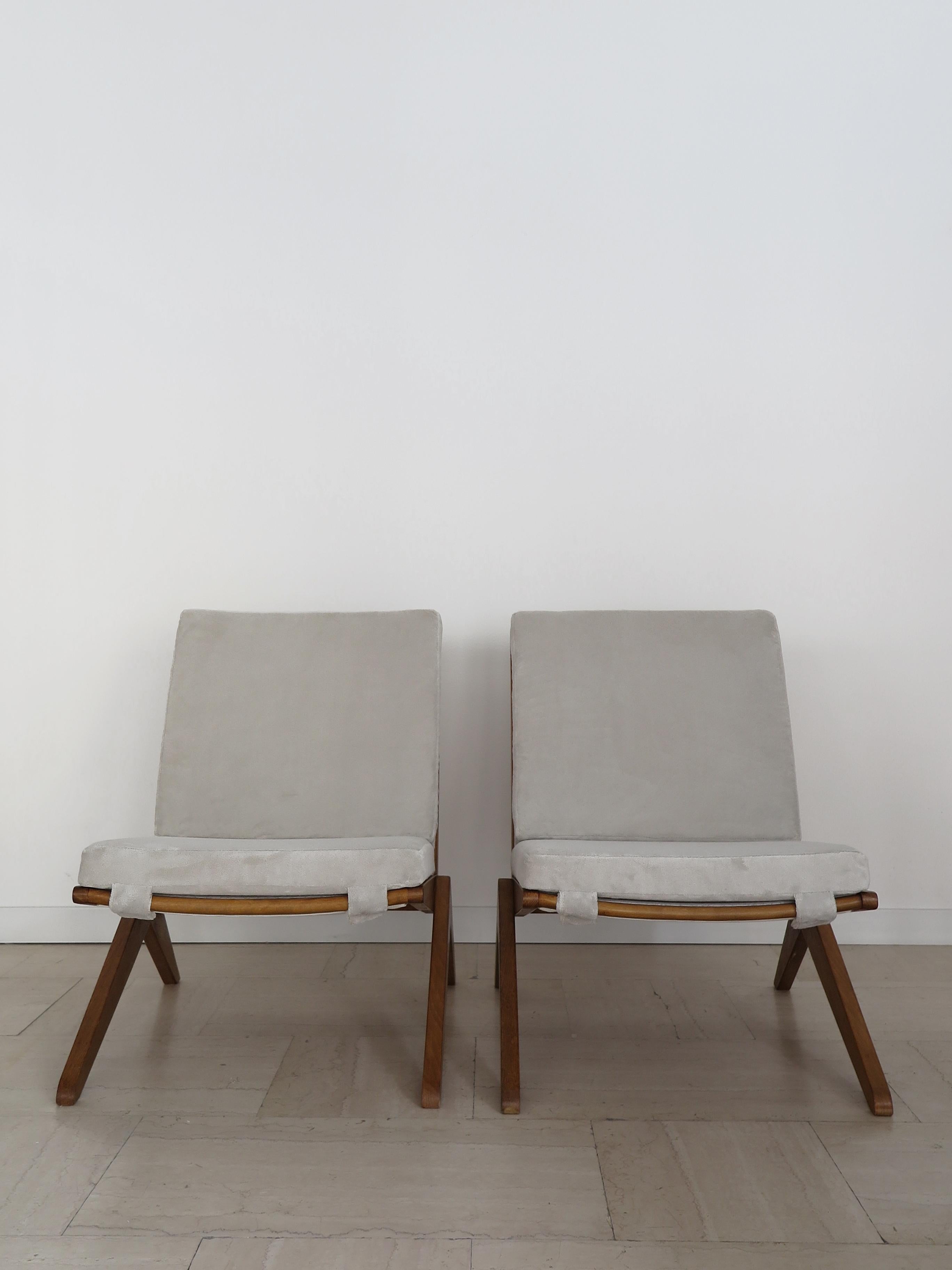 French midcentury modern design couple of armchairs in the style of Pierre Jeanneret with solid wood frame and new velvet-lined seat and back, 1950s France production.

Please note that the armchairs are original of the period and this shows normal