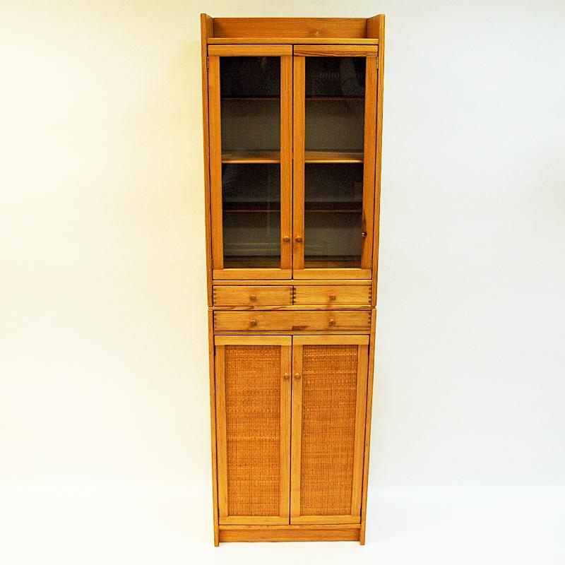 Decorative and beautiful vintage pine cupboard with beaded rotting on lower section doors. Glassdoors and shelves on upper section. Two shelves in the middle or drawers if you prefer. These pine cupboards are named 'Furubo' by its designer Yngve