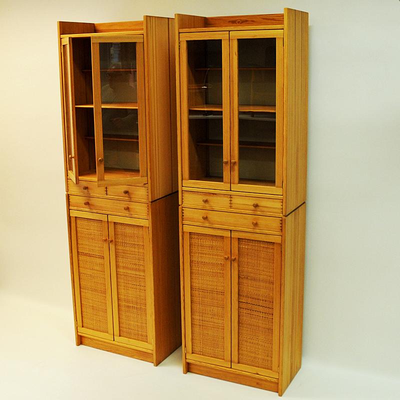 Decorative and beautiful pair of vintage pine cupboards with beaded rotting on lower section doors. Glassdoors and shelves on upper section. Two shelves in the middle or drawers if you prefer. These pine cupboards are named `Furubo` by its designer