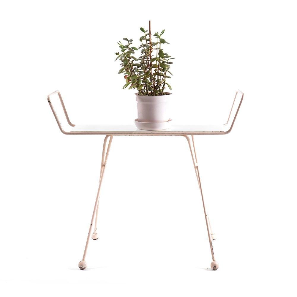 Stylish plant etagere of midcentury design. Metal construction in light pink color holds a white opaline glass board. This is supposed to hold plants or whatever else for that matter. Finished with plastic balls on legs to add to the design.