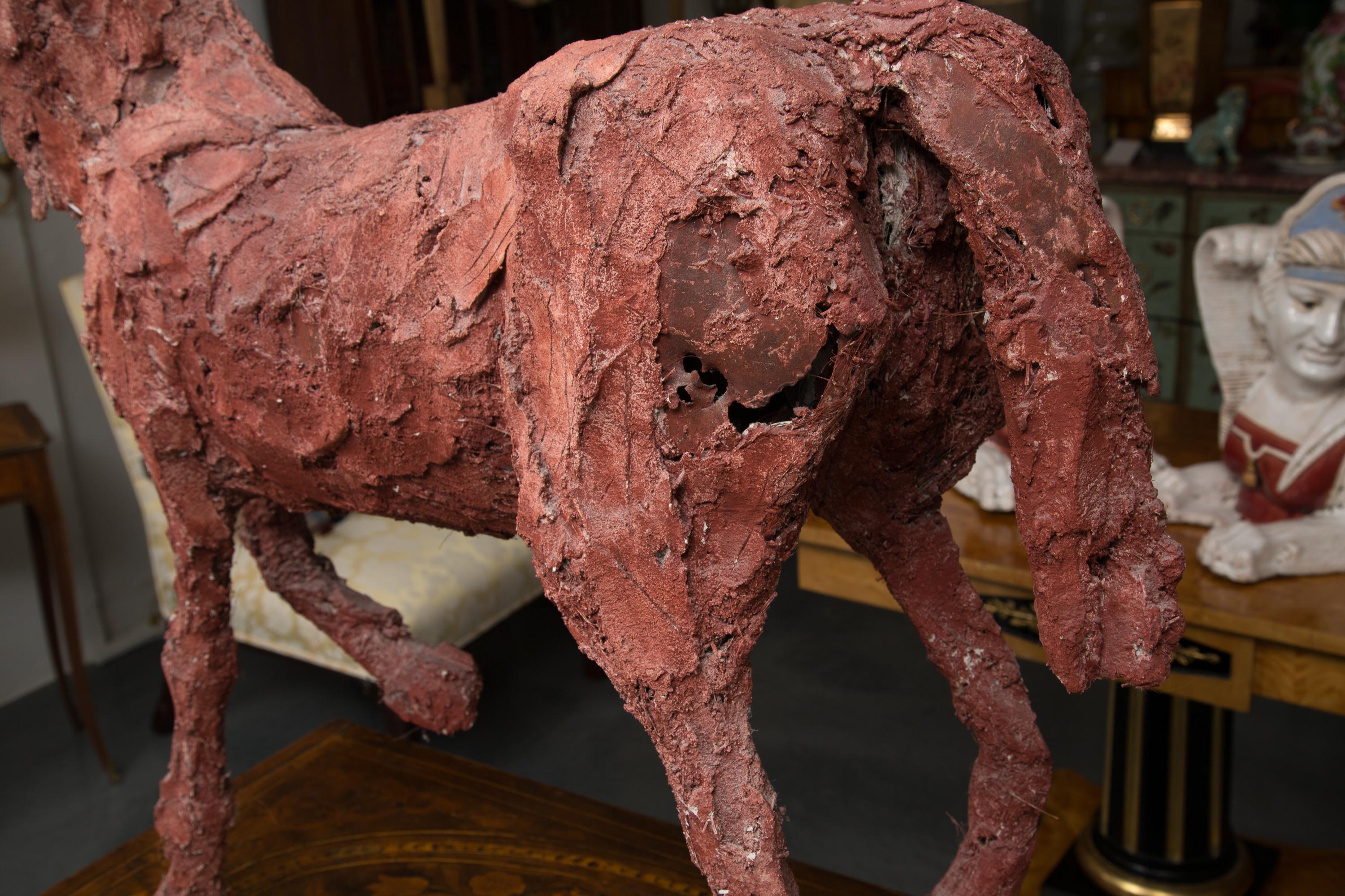 This impressive art piece was created by applying rough materials over a formed  structure. The horse is presented in full form. It appears that the color was added to the clay during the initial application.
The sculpture, by Siri Hollander follows