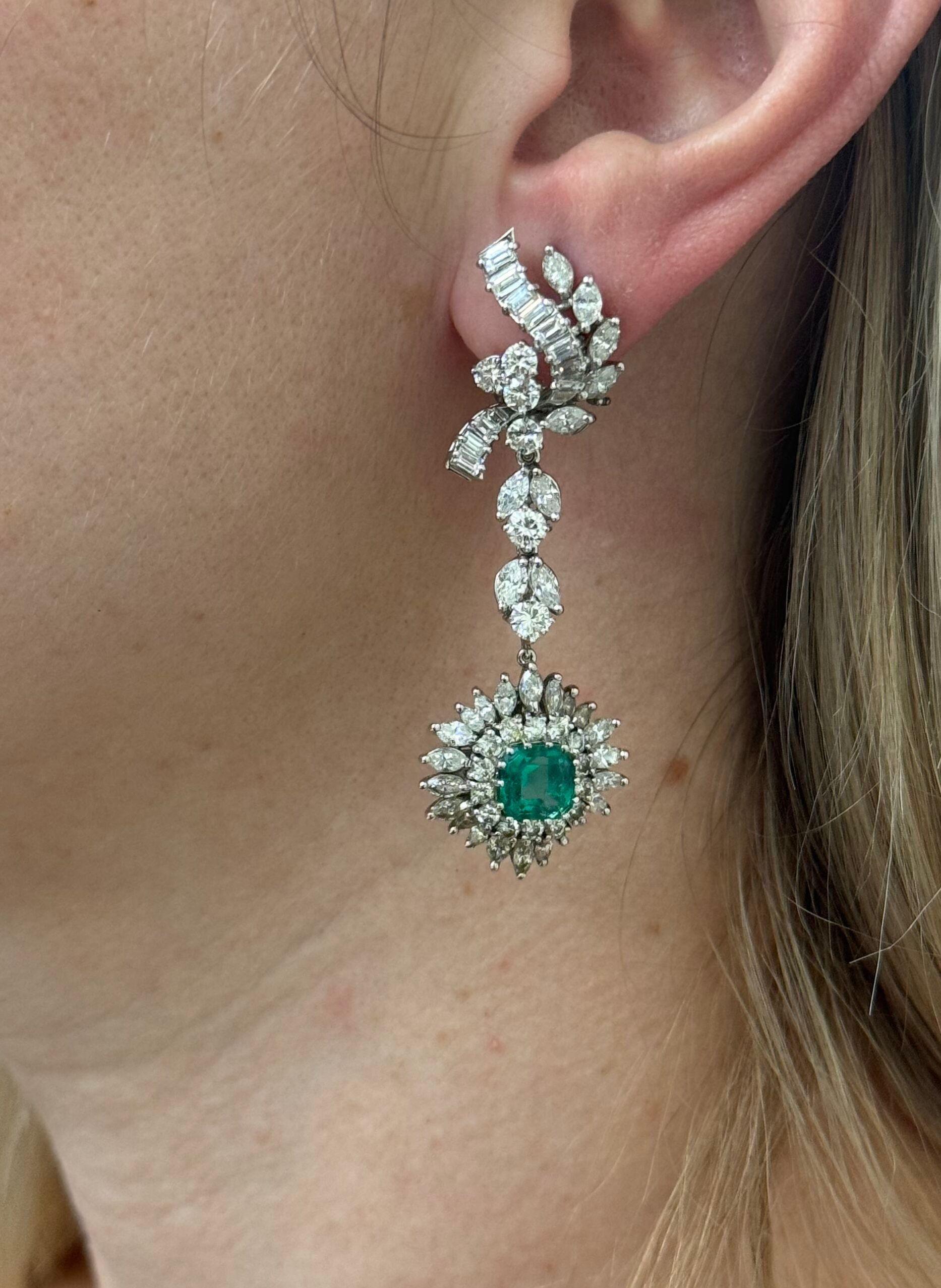 A pair of gorgeous Midcentury 1950s platinum drop earrings, featuring detachable drops. Set with 7.15 x 7mm emeralds, surrounded with approx. 8 carats in VS-SI1/H diamonds. Earrings are 60mm long with the drops and 15mm x 25mm long without them. 