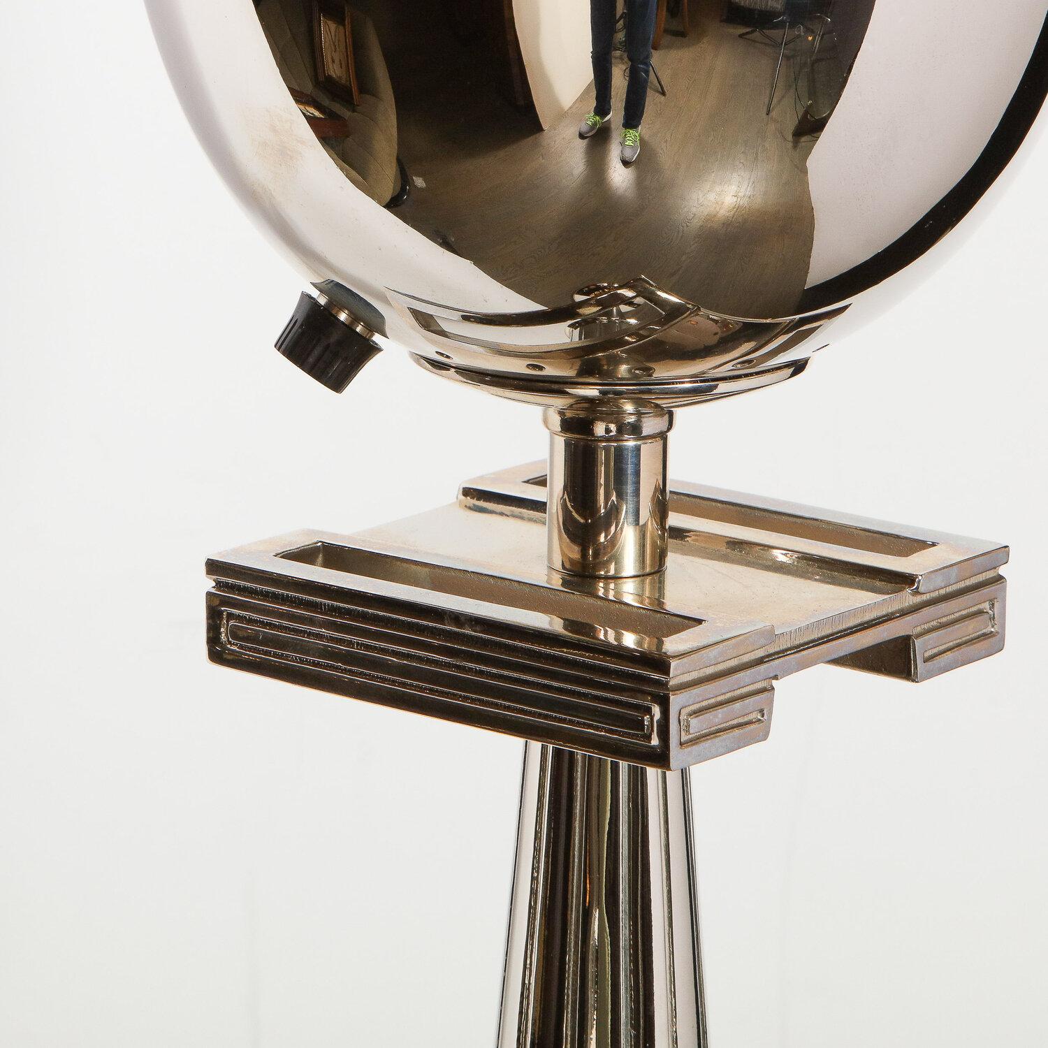 Questa raffinata lampada da terra del Mid-Century Modern è stata realizzata negli Stati Uniti, intorno al 1950. Disegnata alla maniera di Tommi Parzinger, la lampada da terra presenta una base circolare in nichel lucido, un corpo in smalto nero, un