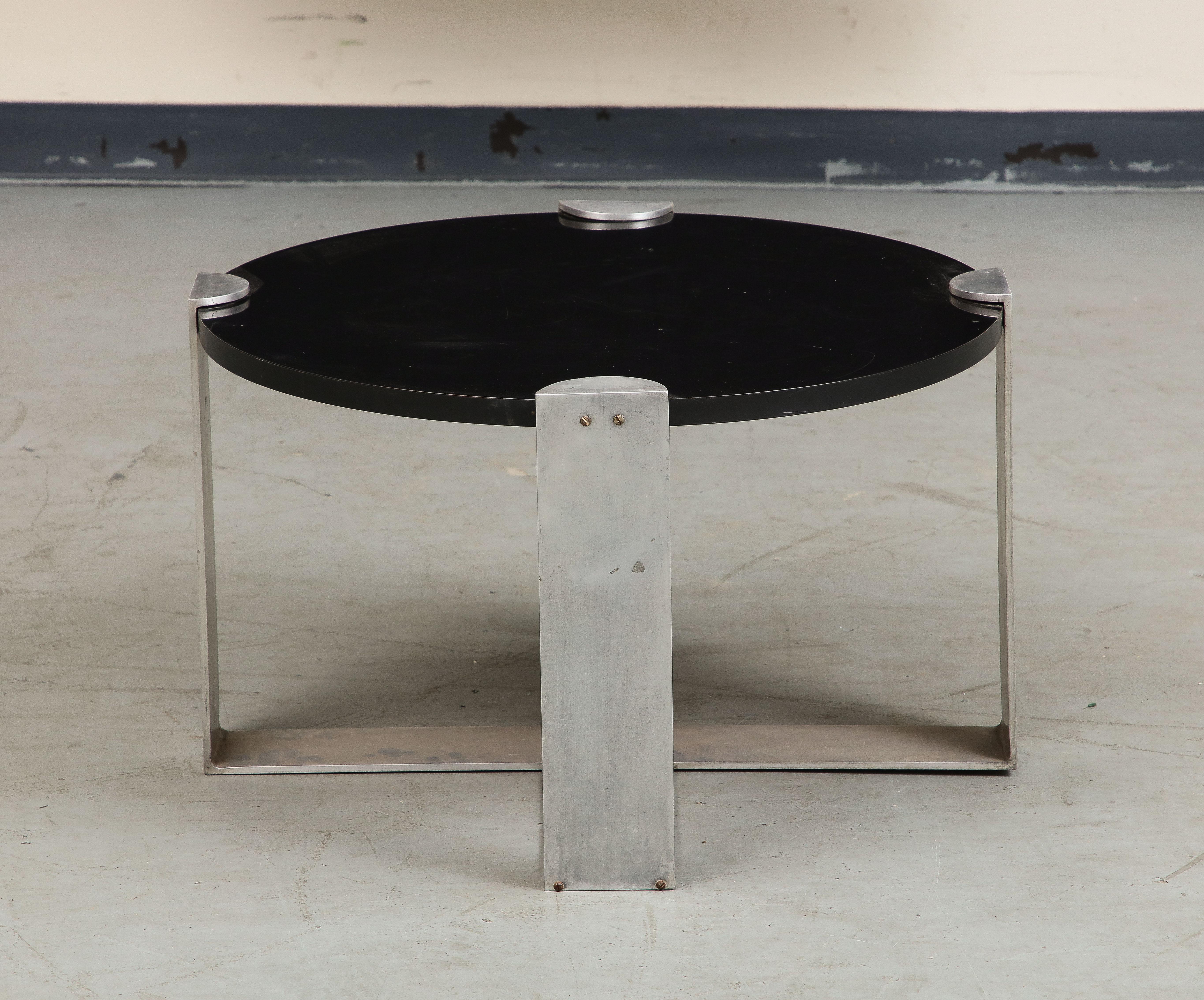 Midcentury coffee table with polished steel base and black wood top, circa 1950.