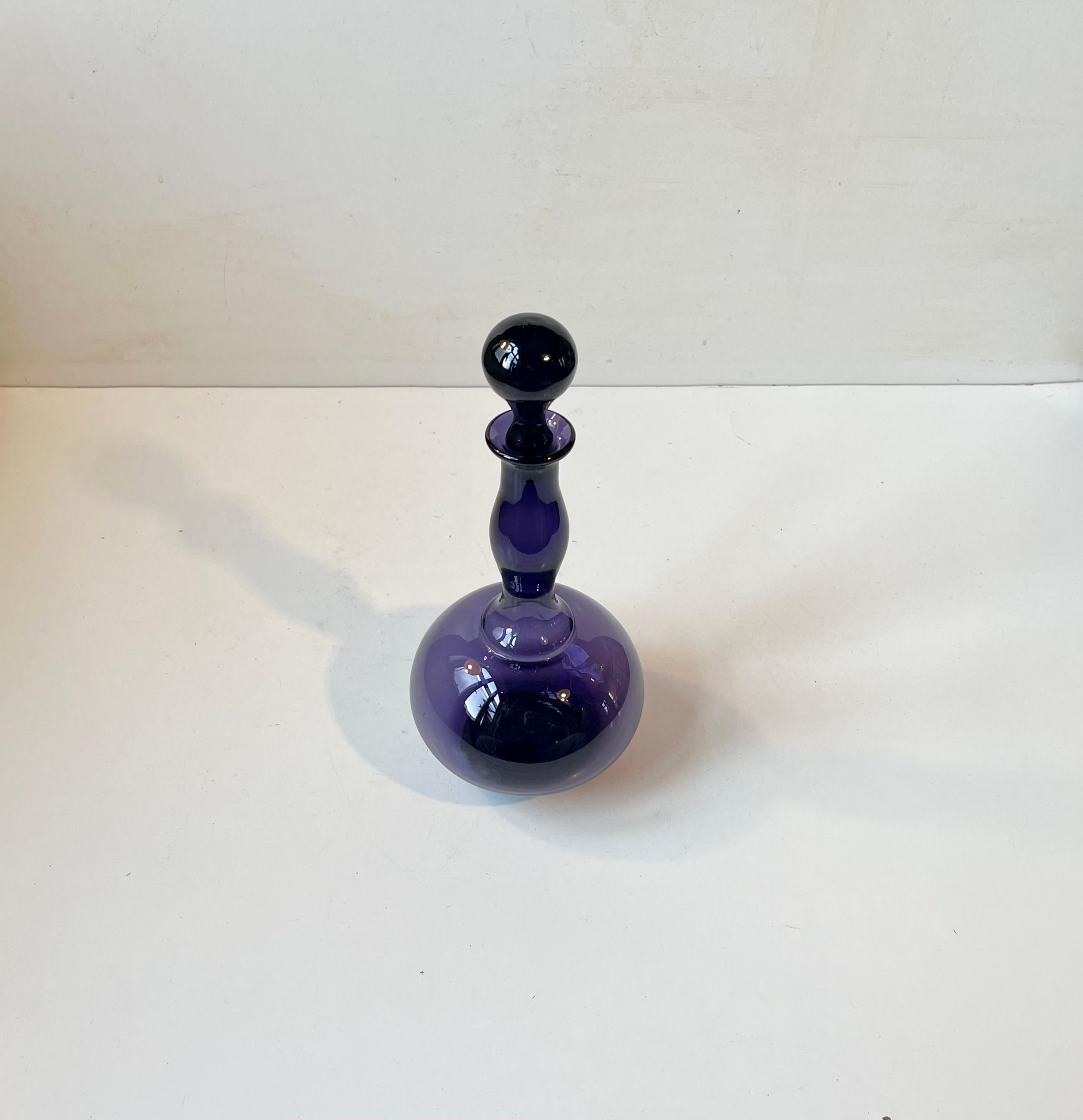 A rare purple - dark violet art glass decanter catalogued as 'No Name, Art Glass' in the Holmegaard Catalogue from 1958. It was designed by Jacob Eiler Bang and hand-blown at Holmegaard in Denmark during the late 1950s. Jacob Bang was the kid bother