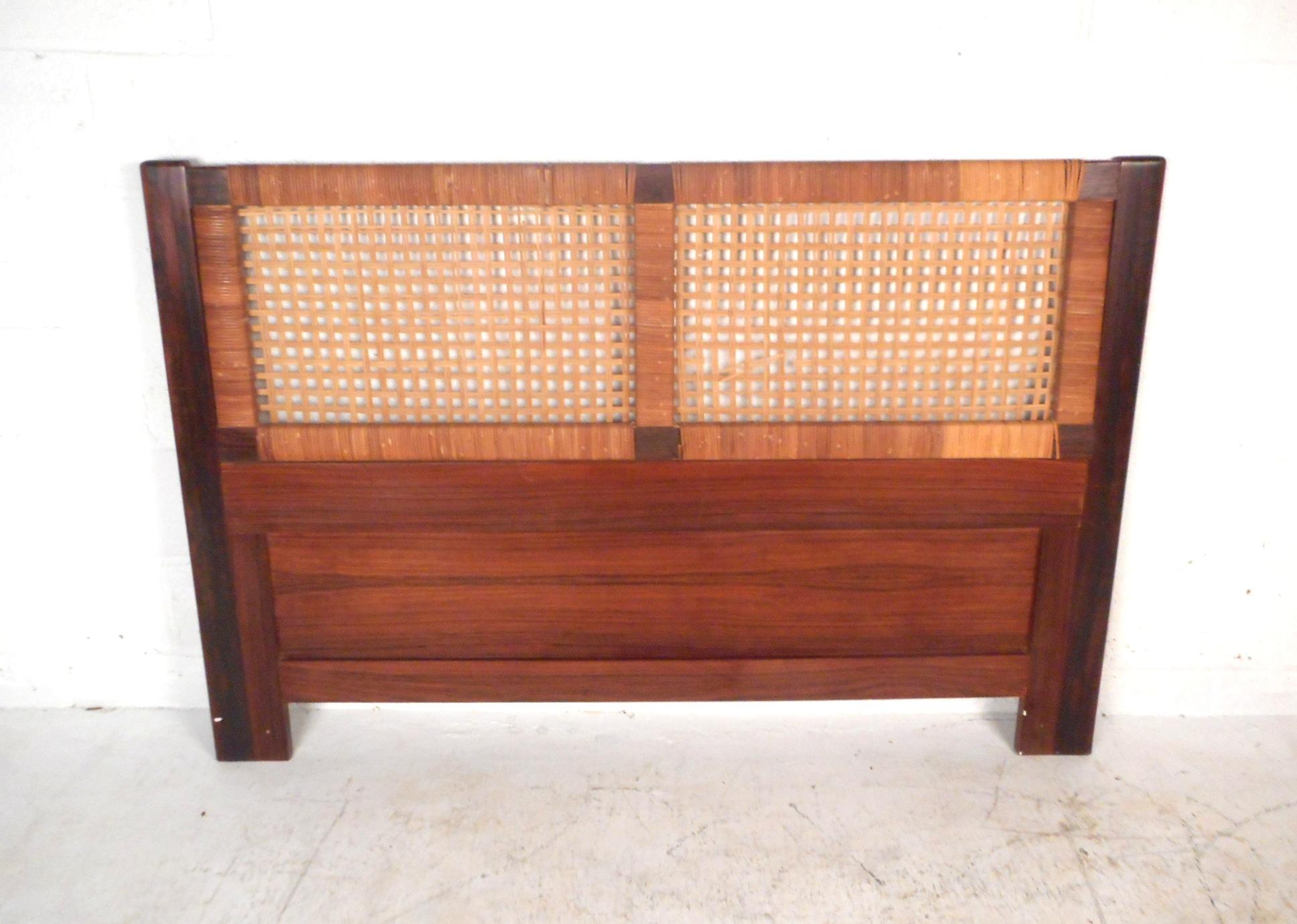 This impressive Danish modern headboard features a rosewood frame and a woven cane centerpiece. This stylish queen sized headboard is sure to compliment any bedroom arrangement. Please confirm item location (NY or NJ).