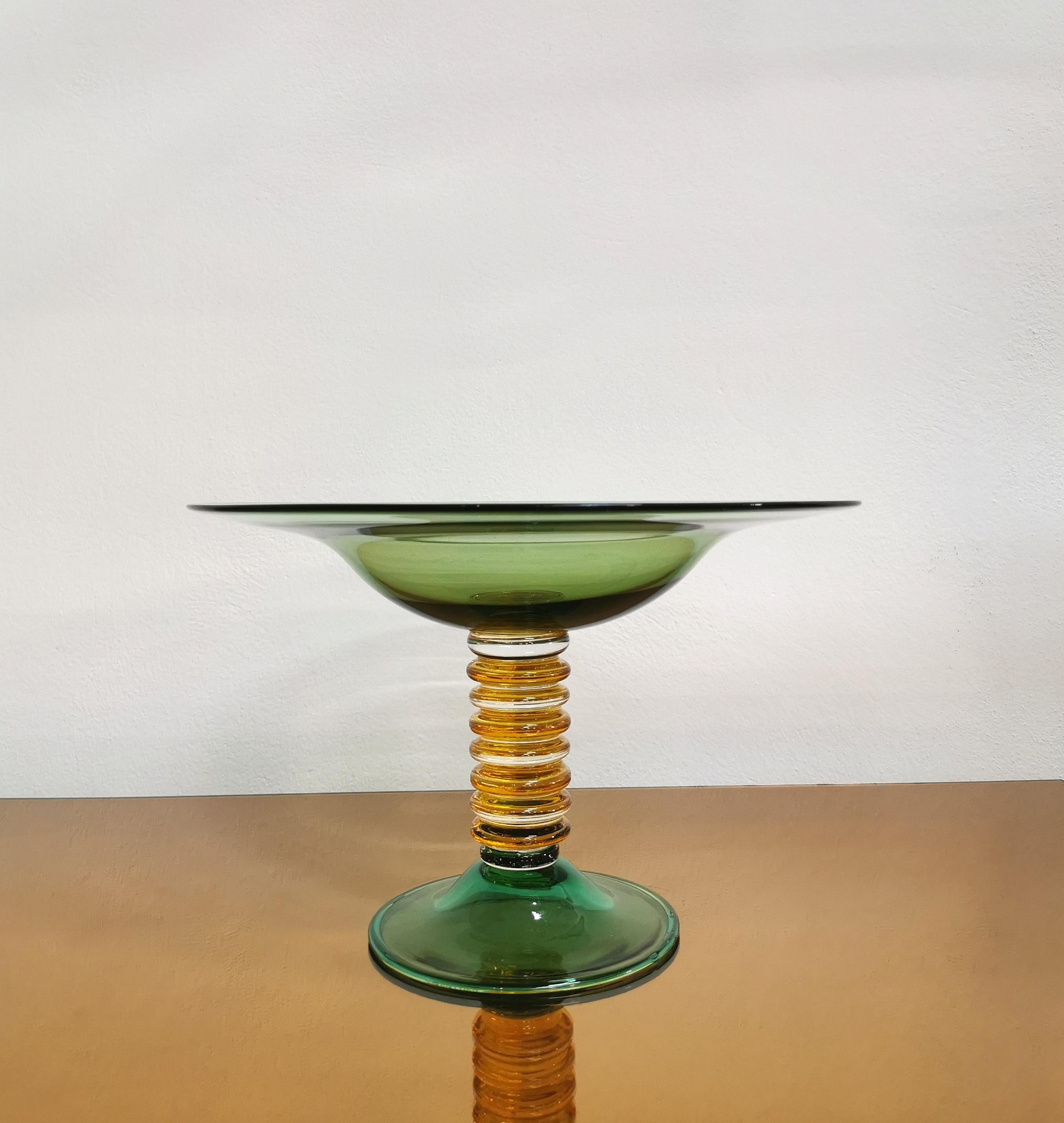 Stand / centerpiece produced by the Venetian company La Murrina in the 70s. The riser is in bottle green Murano glass with a body made of yellow and transparent circular rings.
