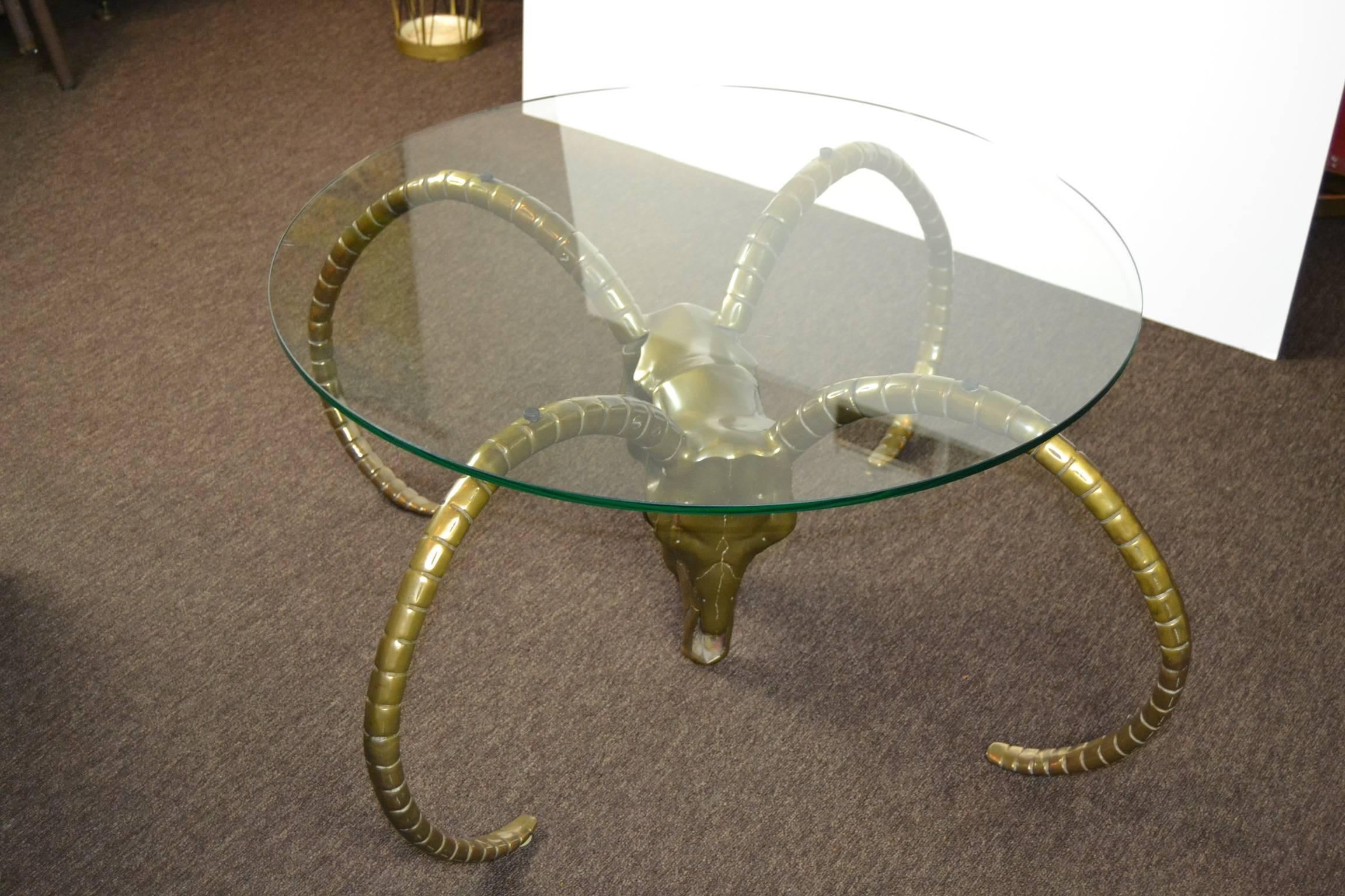 Impressive Ram's Head or Ibex Coffee Table Base from the 1960s.
The heads and horns are made of brass.
You can screw of the horns for cleaning or packaging.
The brass base shows some authentic patina.

Cool coffee table or side table that can fit