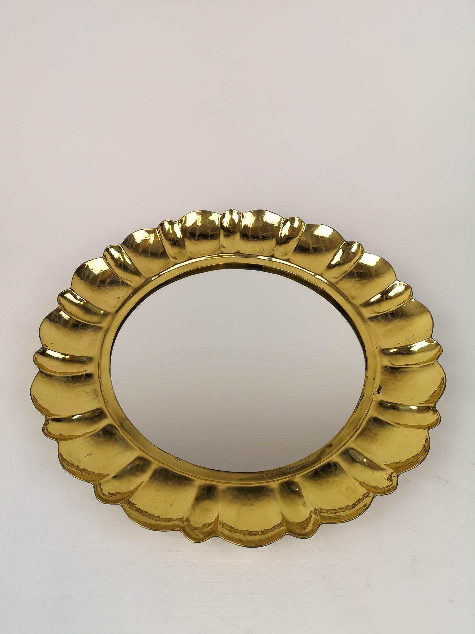 This handcrafted rare mirror made in solid brass was made in Arvika Sweden. The design is by Lars Holmström. The round brass mirror part has been carefully cut and into the brass part there has been placed a mirror. The mirror with its handcrafted