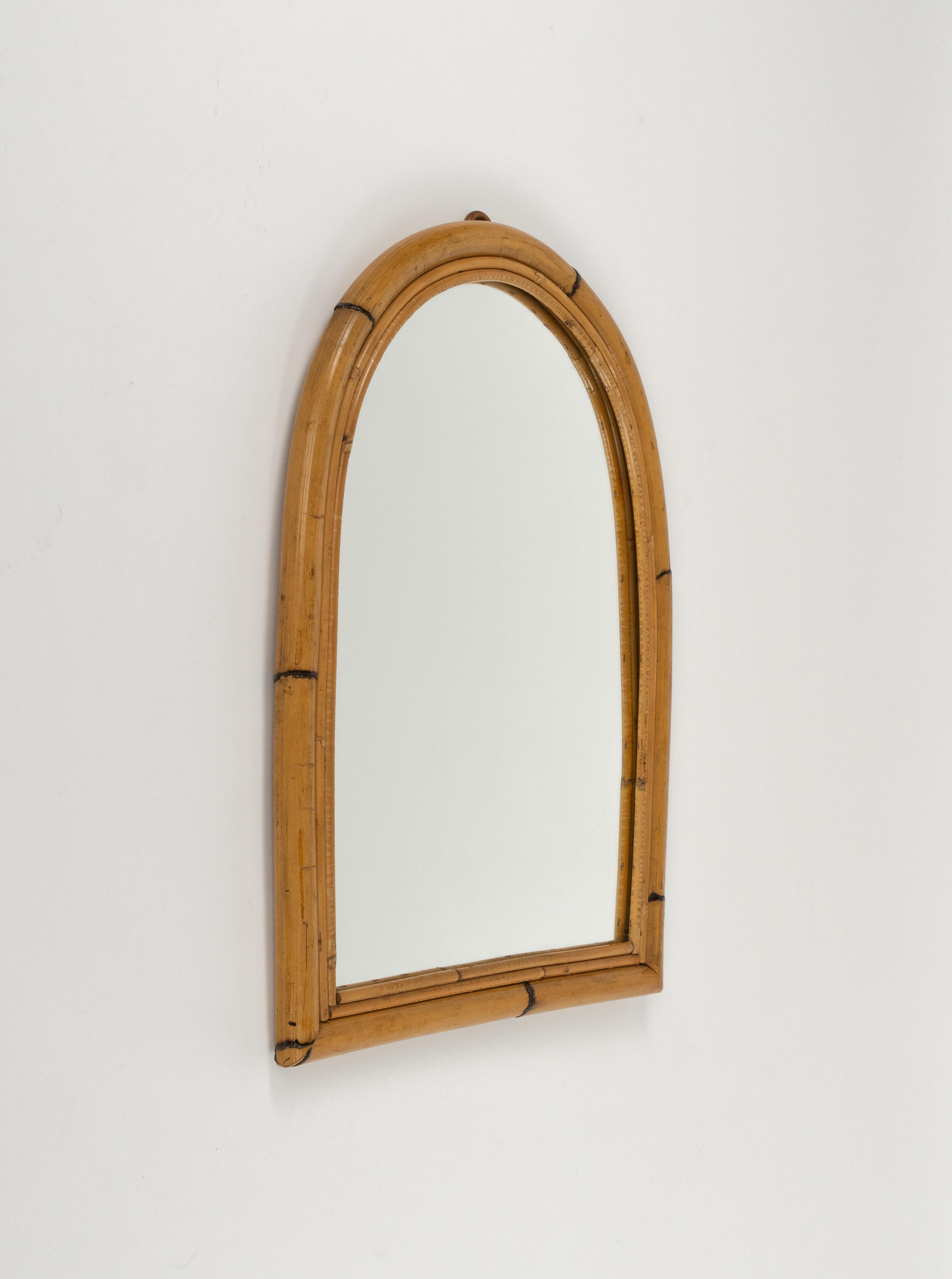 Midcentury beautiful arched wall mirror in bamboo and rattan.

Made in Italy in the 1960s.

The mirror would be perfect for a bedroom, dressing room, cloakroom or hallway.